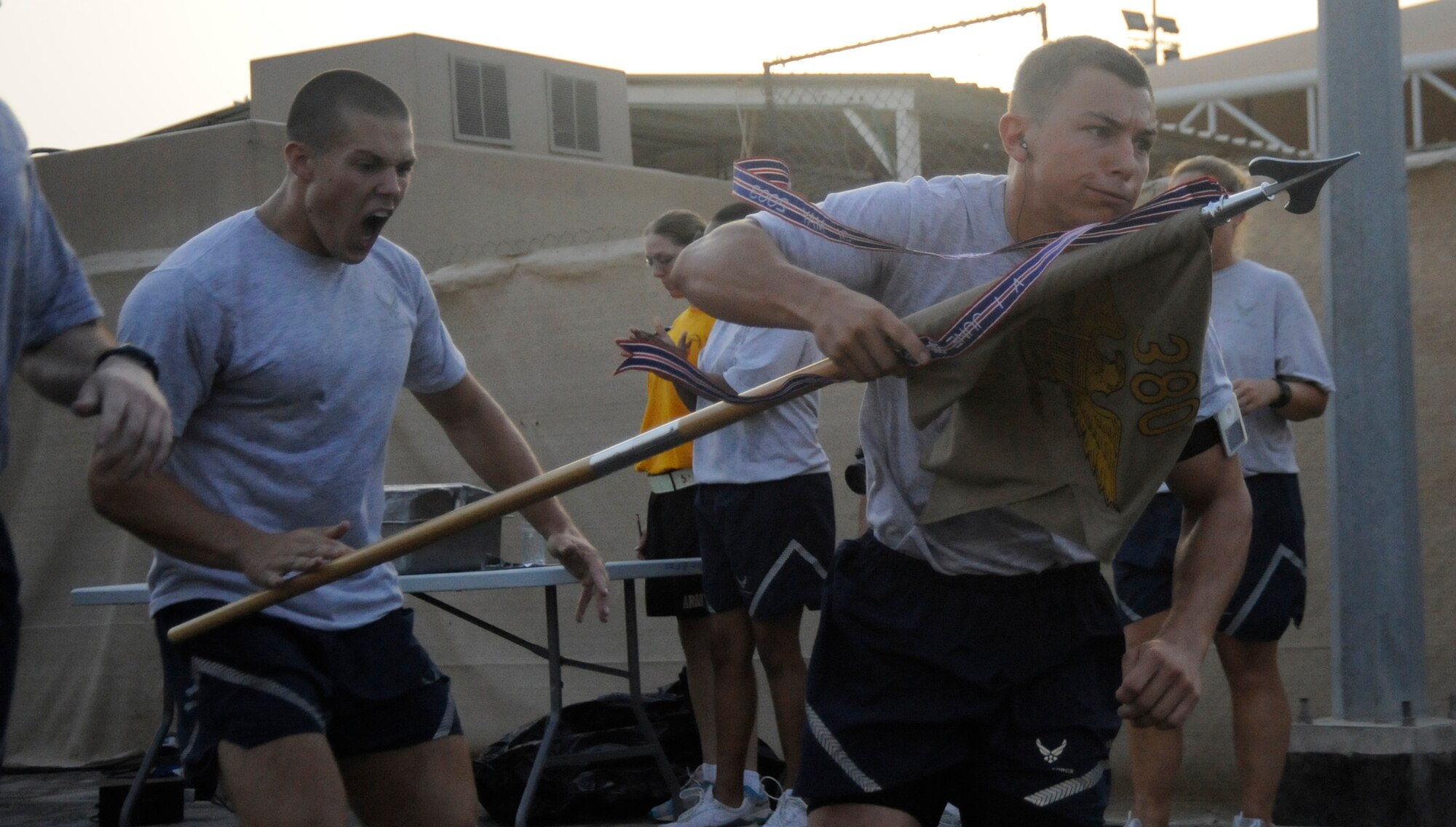 SOUTHWEST ASIA – Cadet 1st Class, Ridge Flick, United States Air Force Academy takes the 380th Air Expeditionary Wing Guidon from Cadet 1st Class Clayton Bryant, USAFA, as he begins the ninth lap here July 22. The Soldiers took the lead in the second lap and were overcome by the Falcons in the seventh. Cadets Flick and Bryant are seniors at the USAFA, Colo. Cadet Flick hails from Dallas, Texas, and Cadet Bryant hails from Charlotte N.C. (U.S. Air Force photo/Senior Airman Stephen Linch)