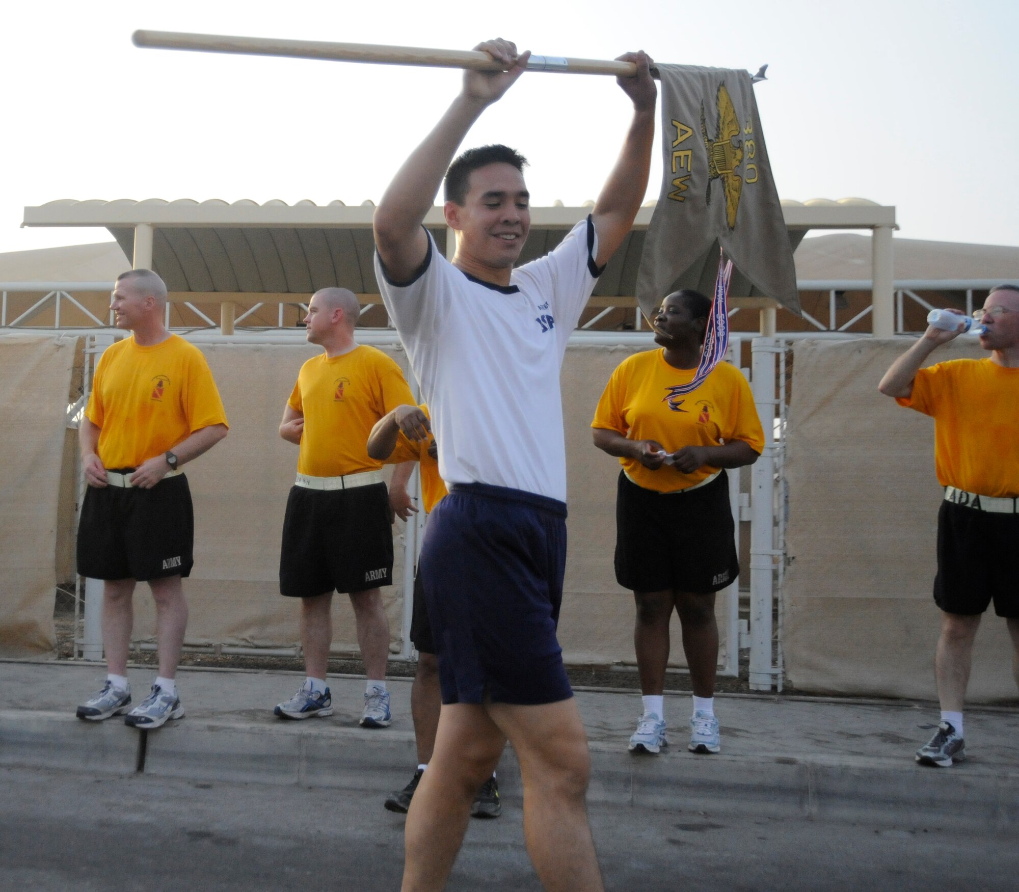 SOUTHWEST ASIA – Cadet 1st Class, Harold Parker, United States Air Force Academy, holds the 380th Air Expeditionary Wing Guidon high after finishing the final lap giving the Falcons a victory over Soldiers here July 22. The Falcons finished the seven mile guidon relay race in 36 minutes and 52 seconds. Cadet Parker is a senior at the USAFA, Colo., and hails from Virginia Beach, Va. (U.S. Air Force photo/Senior Airman Stephen Linch)