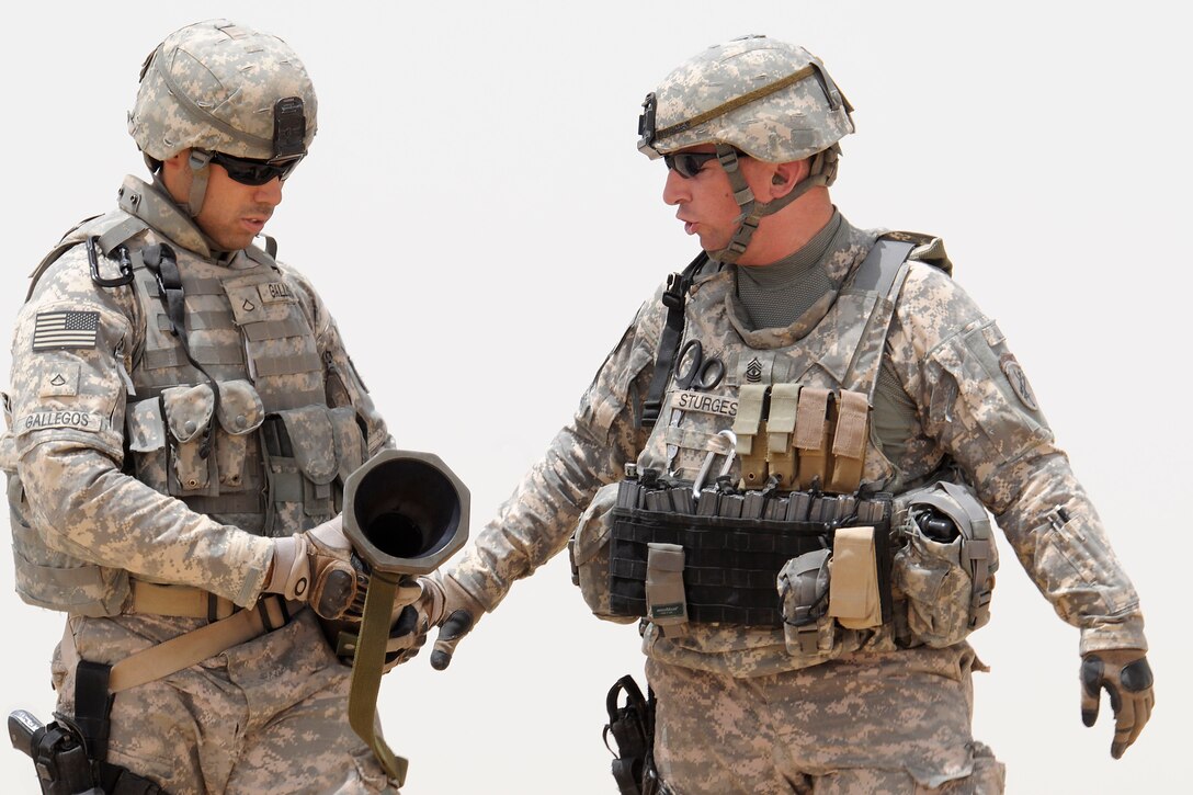 U.S. Army Pfc. Adalberto Gallegos, left, receives training for an anti-tank rocket launcher from 1st Sgt. Benjamin Sturges during tactical range training on Normandy Range Complex in Basra, Iraq, July 15, 2009. Gallegos and Sturges are assigned to Company B, 445th Civil Affairs Battalion.
