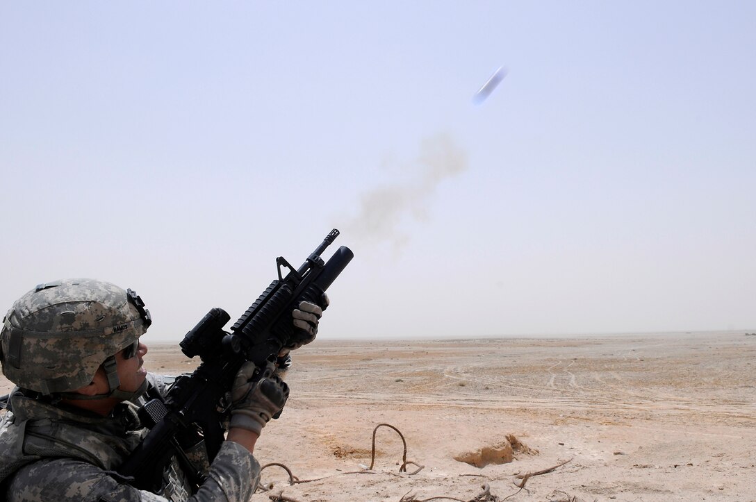 U.S. Army Staff Sgt. Ramon Ramos fires an M-203 grenade launcher down range during the tactical range training on Normandy Range Complex in Basra, Iraq, July 15, 2009. Ramos is assigned to Company B, 445th Civil Affairs Battalion.
