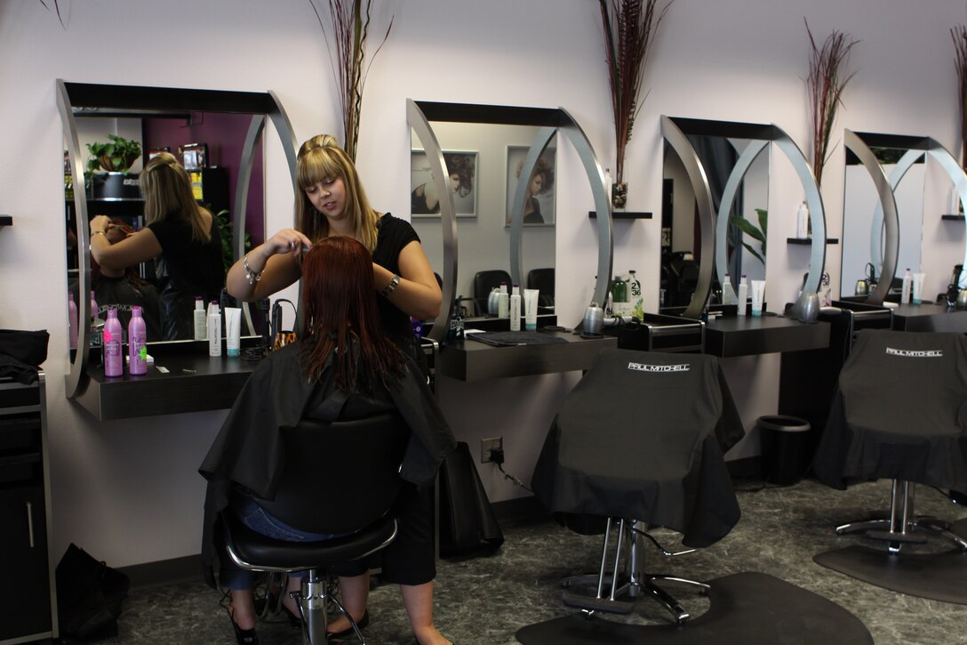Chelsea Wilton, Onyx Salon stylist , trims Melissa Syring's hair at the new salon aboard Camp Pendleton, July 22. The newly remodeled facility is located at Pacific Plaza, near Roberto's Mexican restaurant. Services include basic and style cuts, perms, relaxers, conditioning, waxing, coloring and shampoo treatments from their exclusive "r3" menu.