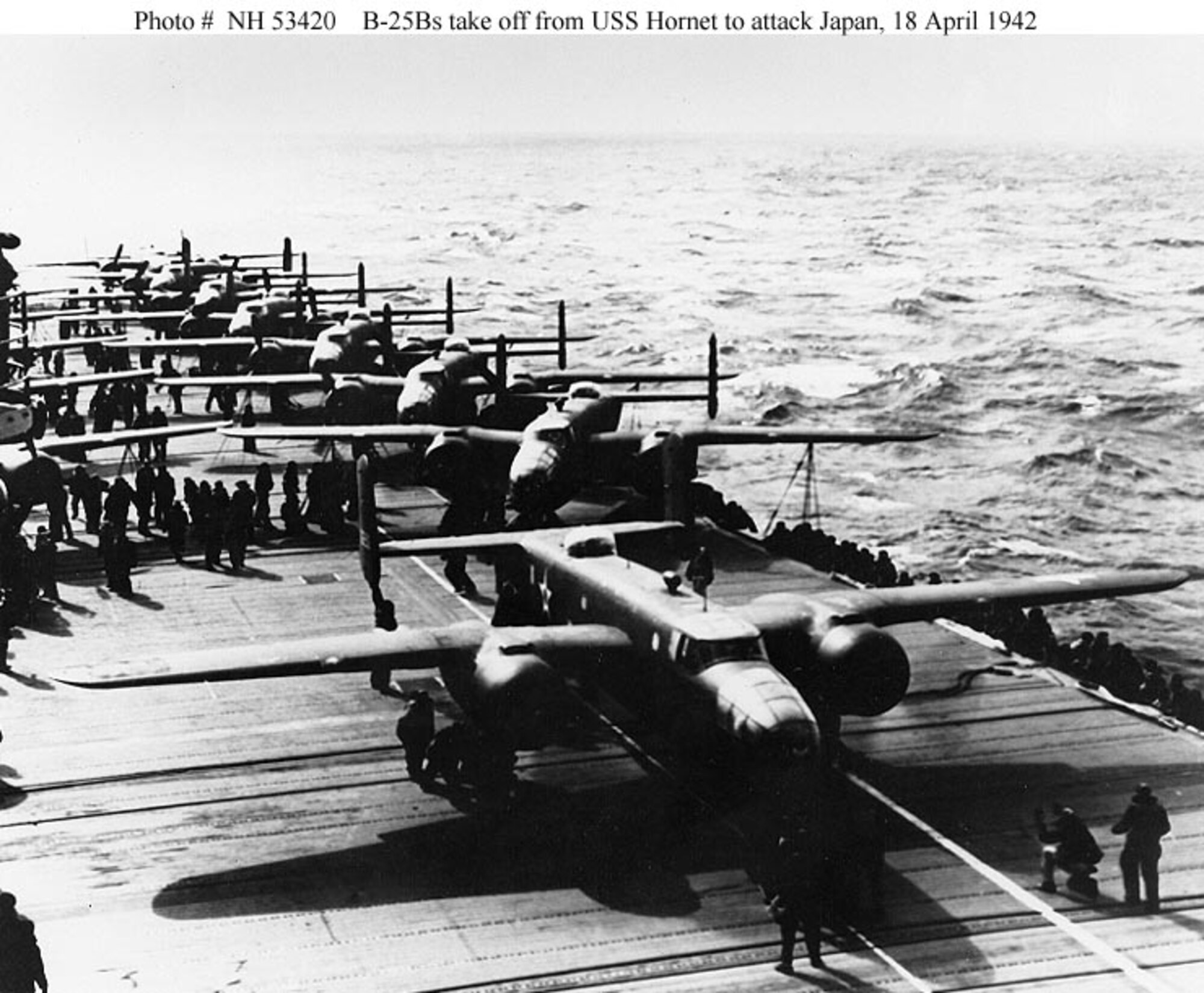 A B-25B bomber lines up for takeoff from USS Hornet (CV-8), on the morning of April 18, 1942. Note white lines painted on the flight deck, below the plane's nose and port side wheels, to guide the pilot during his takeoff run. This is the third or fourth plane to be launched. (U.S. Naval Historical Center Photograph)