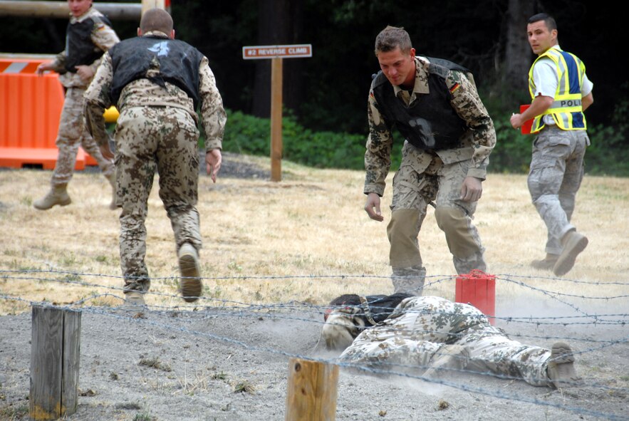 German security forces team members work their way through the endurance course for security forces competition for Air Mobility RODEO 2009 at McChord Air Force Base, Wash.  The course consisted of an obstacle course, 1.5 mile run and litter carry to the finish.  (U.S. Air Force Photo/Capt. Karen O'Neill) 