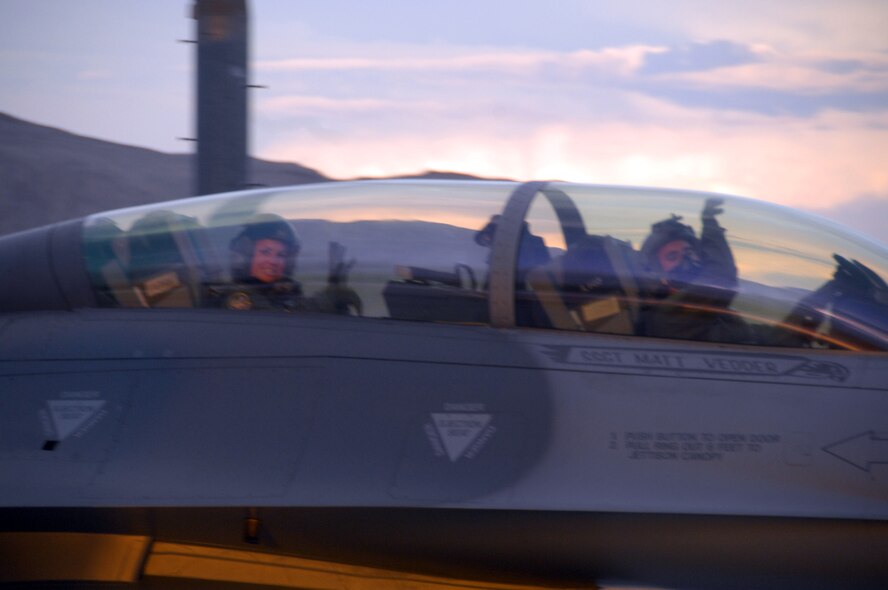 NELLIS AIR FORCE BASE, Nev. -- First Lt. Christina Winn (left), 79th Fighter Squadron intelligence, and Capt. Geff Gebhardt, 79th FS "Tigers" pilot, throw up their "paws" as they taxi to the runway during a Green Flag exercise. This exercise provides the Tigers with two weeks of close air support training in preparation for their deployment to Afghanistan in October. (U.S. Air Force photo/2nd Lt. Emily Chilson)