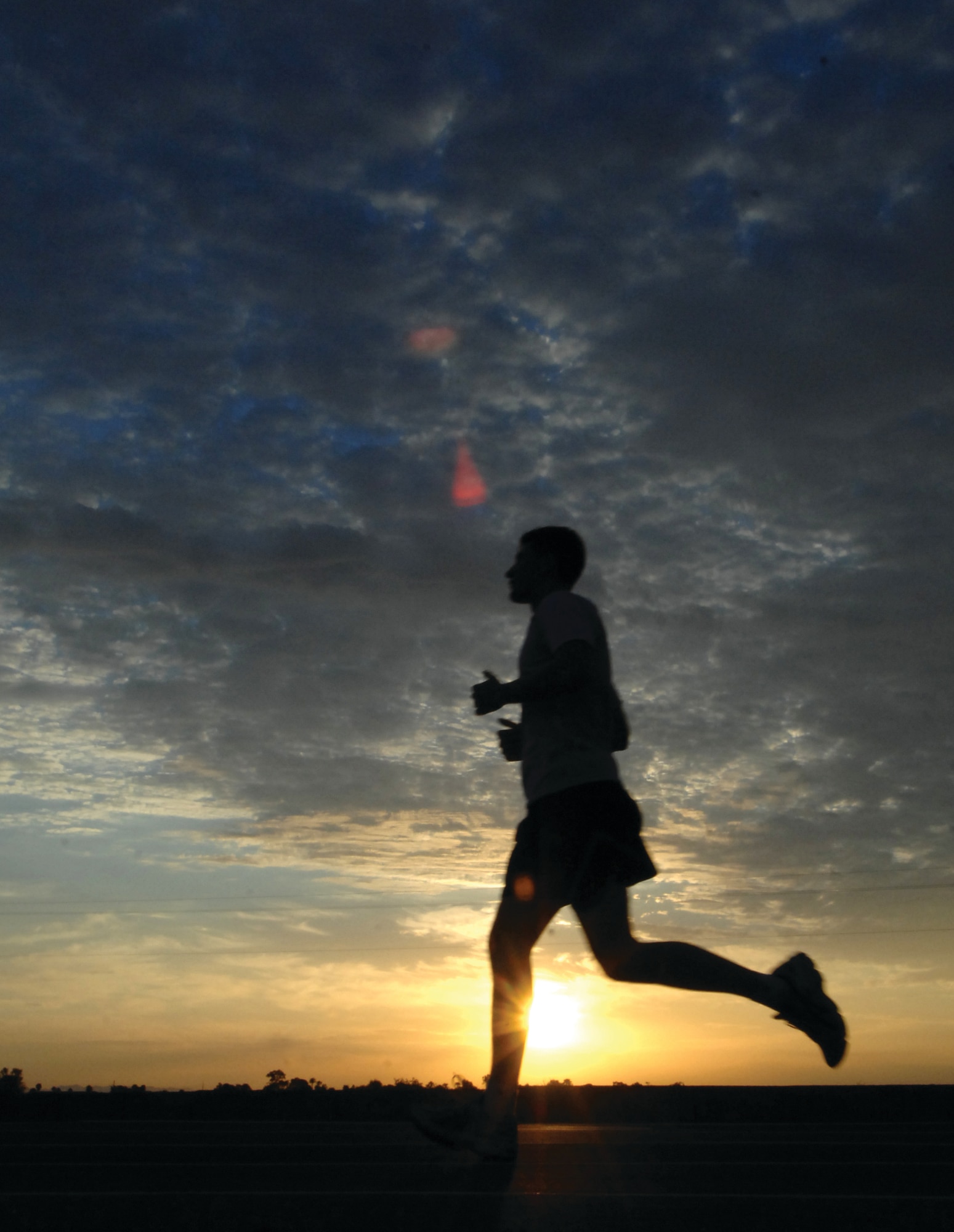 A 56th Fighter Wing Airman runs laps at the base track for morning physical training as the sun starts to peek over the horizon. Airmen have accepted the Air Force policy of being “fit to fight” and Luke Air Force Base is an example of a base adapting to the fitness culture. (Photo by Tech. Sgt. Jeffrey Wolfe)