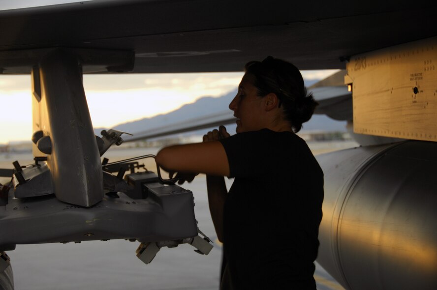 NELLIS AIR FORCE BASE, Nev. -- Senior Airman Cassie Casaras, 79th Aircraft Maintenance Unit, removes an inert munition from an F-16CJ during a Green Flag exercise. Pilots drop both live and inert munitions while training to provide close air support to ground forces. The overall mission of Green Flag is to prepare units for deployment. (U.S. Air Force photo/2nd Lt. Emily Chilson)