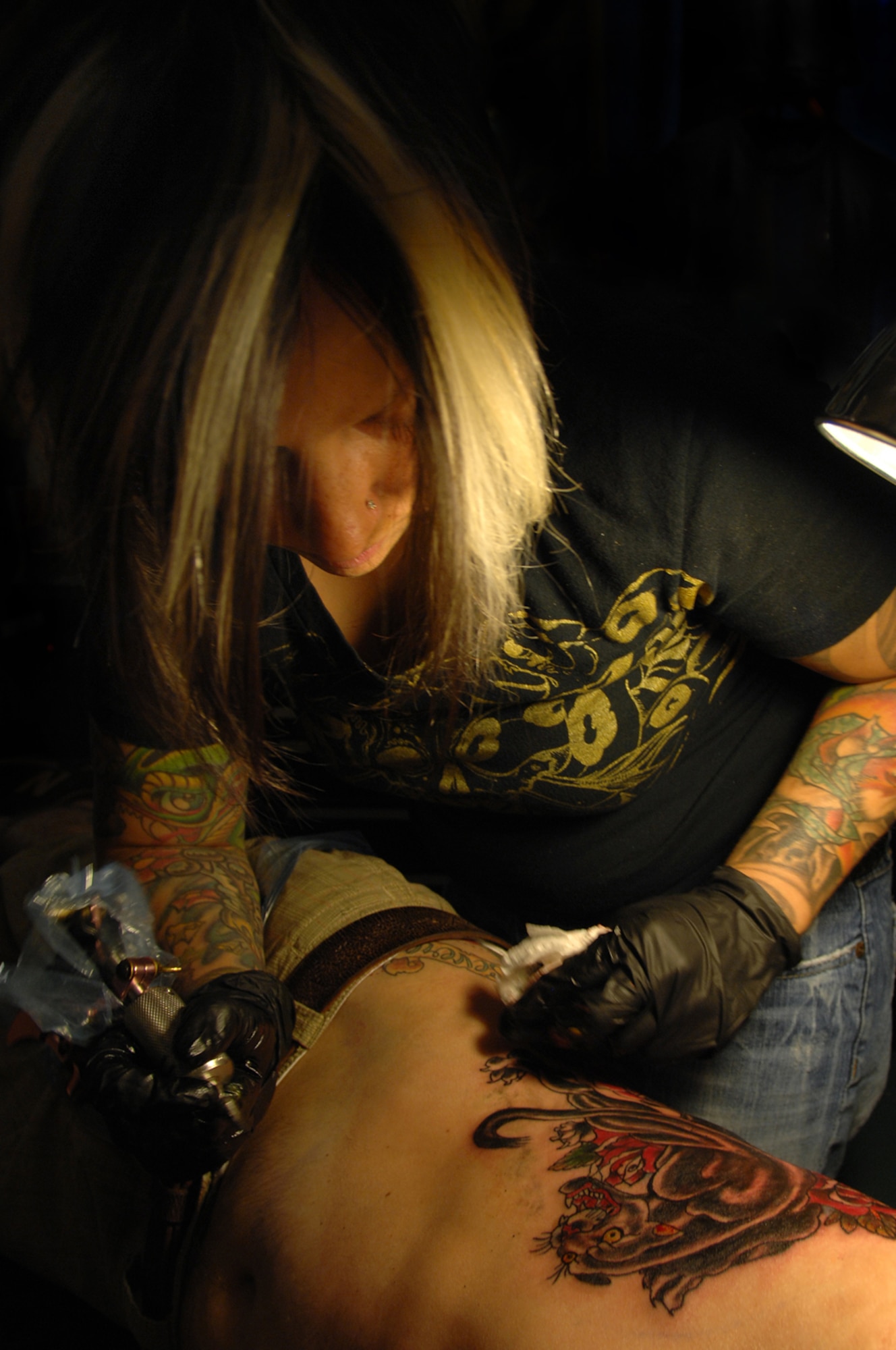 KANSAS CITY, Mo. - Jen Beirola, prior U.S. Air Force enlisted, prepares to irrigate a fresh tattoo after putting the finishing touches on it at an annual tattoo convention July 19. Jen discovered her talent while serving in the Air Force and was inspired by the late graphic artist career field. Military members stationed at Whiteman were able to attend the convention and watch tattoo arts such as Jen perform their craft. (U.S. Air Force photo/Senior Airman Kenny Holston)