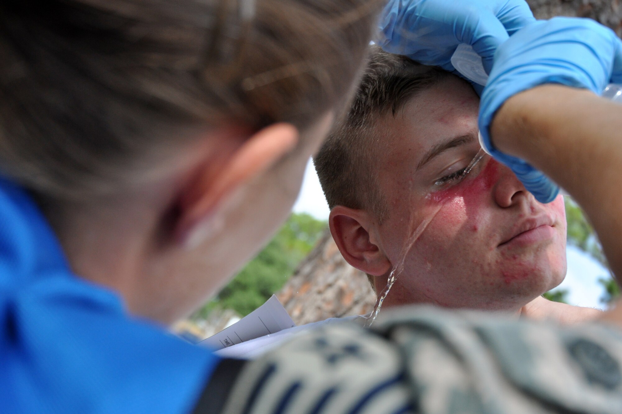 EGLIN AIR FORCE BASE, Fla. – Tech. Sgt. Stephanie Belter, 96th Aerospace Medicine Squadron, flushes a victim’s eyes with water during an exercise here, July 22. The exercise evaluated first responders and medics reaction to real-world crisis scenarios. The simulated explosion injured approximately 40 people and fatally wounded 13. The exercise also evaluated the base’s response to a threat situation with increase Force Protection levels. (U.S. Air Force photo/ Airman Anthony Jennings)