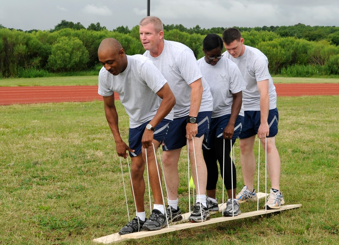 LANGLEY AIR FORCE BASE, Va. --  Chief Master Sgts.  Yance Childs and Harold Clark participate in a team building exercise with Senior Airman Jolanda Leal and Airman Jeffery Hartman here July 23.  The team building exercise was a part of the Airmen Committed to Excellence and Chiefs Day, Air Combat Command and the 1st Fighter Wing came together to participate in a fun day of mentoring Airman. The day included physical training activities and Airmen shadowing a Chief for the day. (U.S. Air Force Photo/Senior Airman Dana Hill)