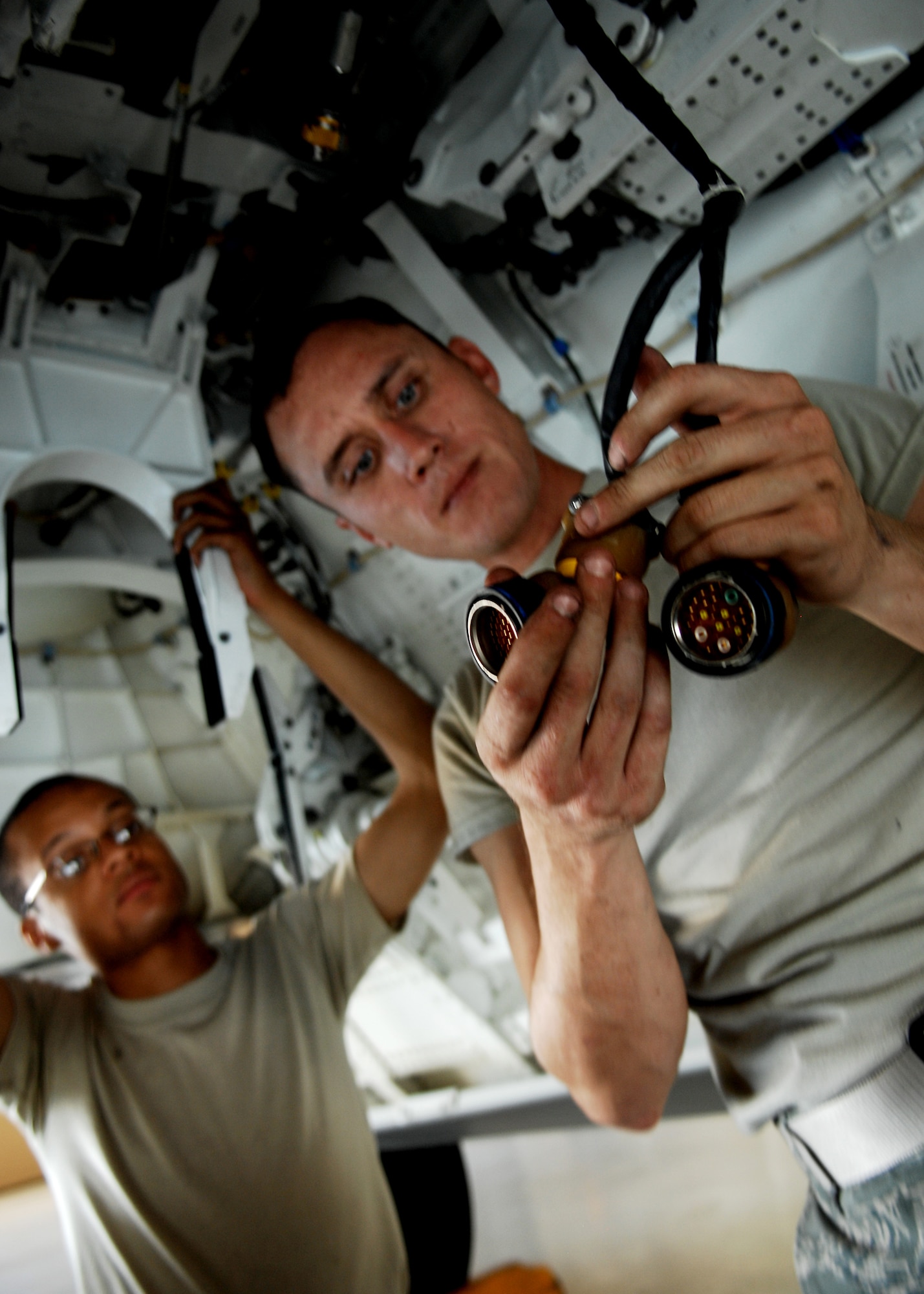 Senior Airman David Smith and Staff Sgt. William Soto, inspects the LAU-142 ( (Launcher Unit) wire harness after learning how to perform primitive maintenance 90-day inspection and remove\install of equipment task on a
F-22A Raptor, July 15 at Holloman Air Force Base, N.M. Both Airmen were students in the F-22A Raptor Armament Weapons Bay Door System and Suspension Components Maintenance Course. This class is a cross over class, teaching airmen who use to work on prior aircraft to the new F-22. 

 (U.S. Air Force photo/SSgt Anthony Nelson Jr)