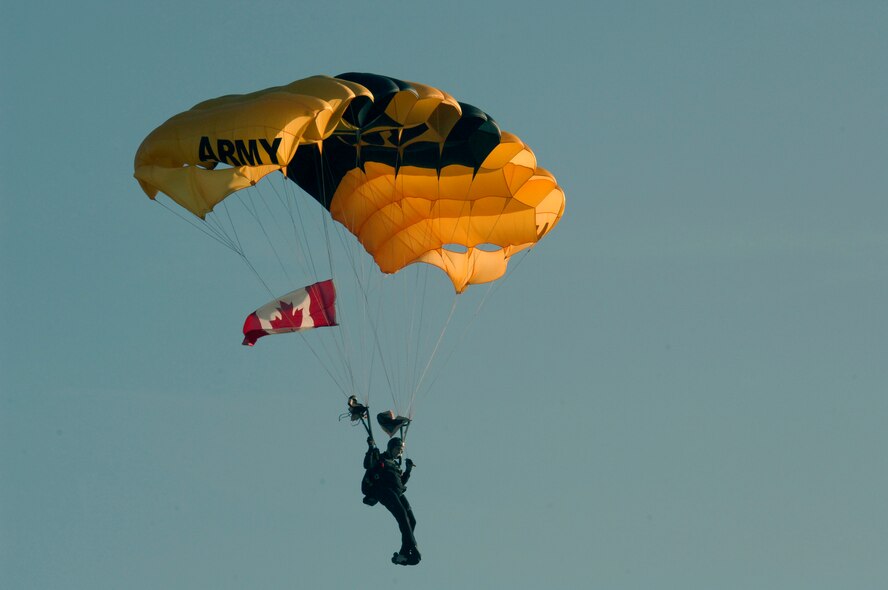 MINOT AIR FORCE BASE, N.D. -- A member of the U.S. Army Golden Knight parachute team descends on Minot with the Canadian flag during the Northern Neighbors Day festivities here July 18. Thousands of people from the base and local community turned out to watch the 2009 Northern Neighbors Day, which came through on its promise to wow spectators with amazing aerial maneuvers, nail-biting choreography, historic displays and much more. (U.S. Air Force Photo by Airman First Class Jesse Lopez)
