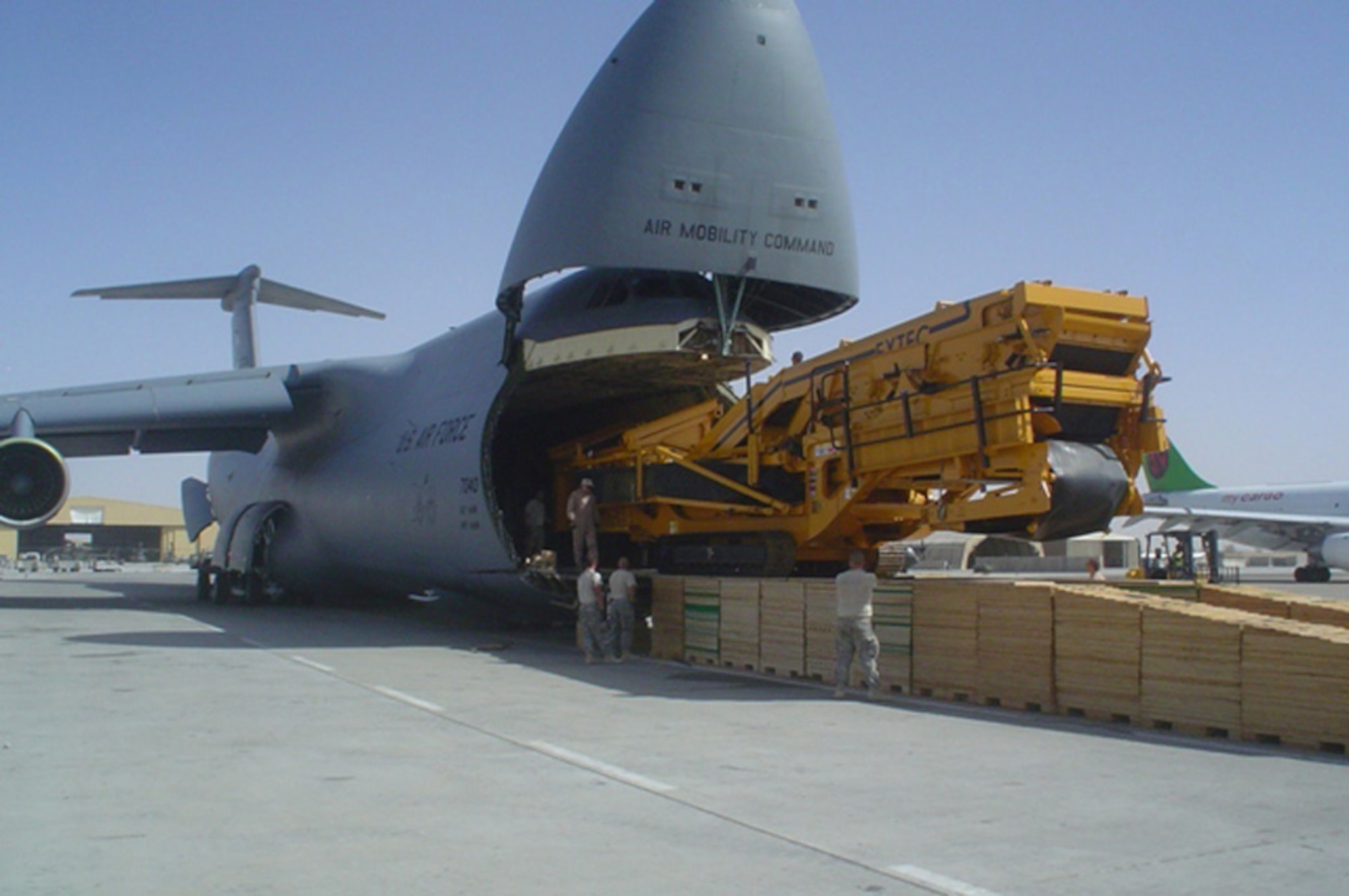 The second of two pieces of rock crushing equipment, assets of the 819th RED HORSE Squadron here, gets off-loaded from a C-5 June 24 in Afghanistan. Total weight of the cargo, including the shoring which also had to be shipped, was 168,385 pounds. (U.S. Air Force photo/Tech. Sgt. John Cottle)