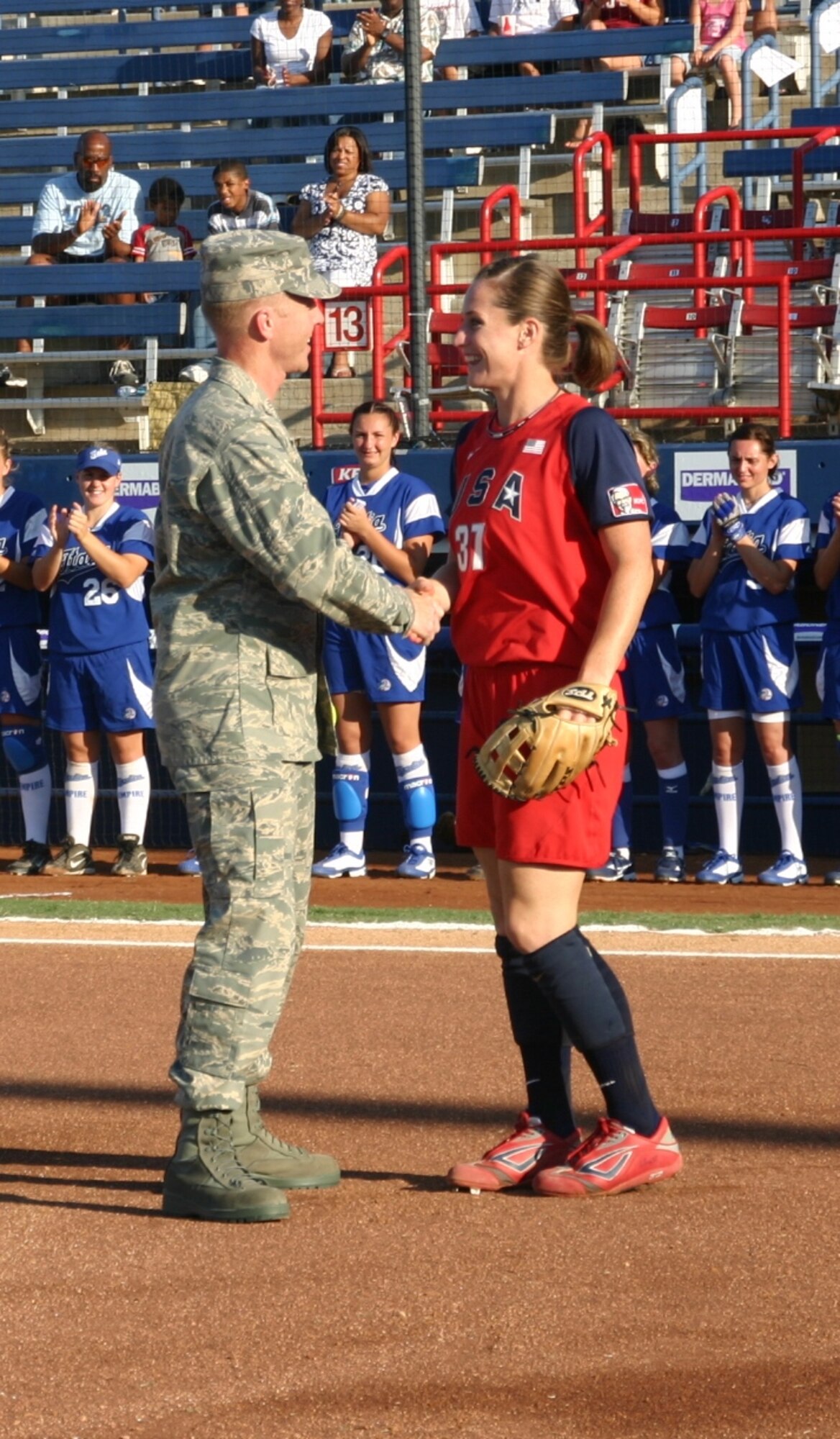 Col. Scott Forest, vice commander, 552 ACW, shakes the Team USA catcher's hand after throwing her the first pitch as part of Military Appreciation Night at the World Cup of Softball July 17.