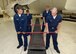 Navy maintainers use Kevin Hart’s Grating Removal Tool to lift a grate in a maintenance hangar here. The tool was created to help alleviate the stress of removing the 200-pound grates to clean the trenches. (Air Force photo by Margo Wright)