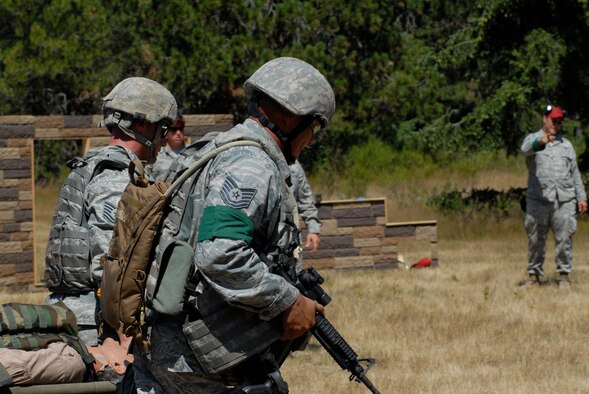 MCCHORD AIR FORCE BASE, Wash. -- Tech. Sgts. James Howard and Juan Felix 15th Security Forces Squadron, Hickam Air Force Base, Hawaii, finish an Air Mobility Rodeo 2009 event with fellow teammates Senior Master Sgt. Matthew Friedman and Staff Sgt. Kevin Ong (not shown). SFS specialists had to complete a course which required them to find and care for a “wounded” person, carry the litter while traversing a wooded path, take the casualty to safety, sprint to M-4 and M-9 shooting ranges, and successfully break ceramic plate targets while wearing gas masks. Hickam AFB’s team prepared for the event by doing six weeks of intense physical training including wind sprints and unconventional weight training. (U.S. Air Force photo/Staff Sgt. Carolyn Viss)