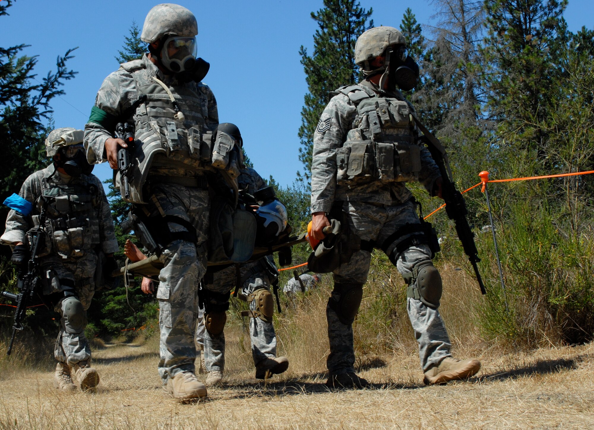 MCCHORD AIR FORCE BASE, Wash. -- Tech. Sgts. James Howard and Juan Felix, front, and Senior Master Sgt. Matthew Friedman and Staff Sgt. Kevin Ong, rear, 15th Security Forces Squadron, Hickam Air Force Base, Hawaii, carry a 225-pound litter patient dummy during an Air Mobility Rodeo 2009 event here July 21. Security Forces have historically provided flightline security and perimeter base defense; now, they are also called upon to operate “outside the wire.” This Rodeo event highlighted their readiness and ability so survive and operate in wartime. (U.S. Air Force photo/Staff Sgt. Carolyn Viss)