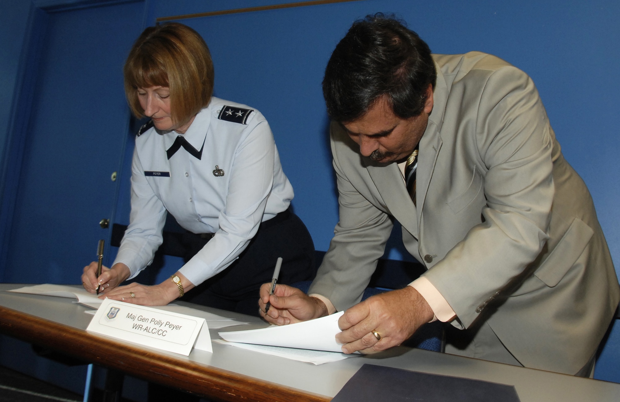 Maj. Gen Polly Peyer, WR/ALC commander, and Tom Scott, American Federation of Government Employees Local 987 president, sign a memorandum of agreement. U. S. Air Force photo by Claude Lassara
