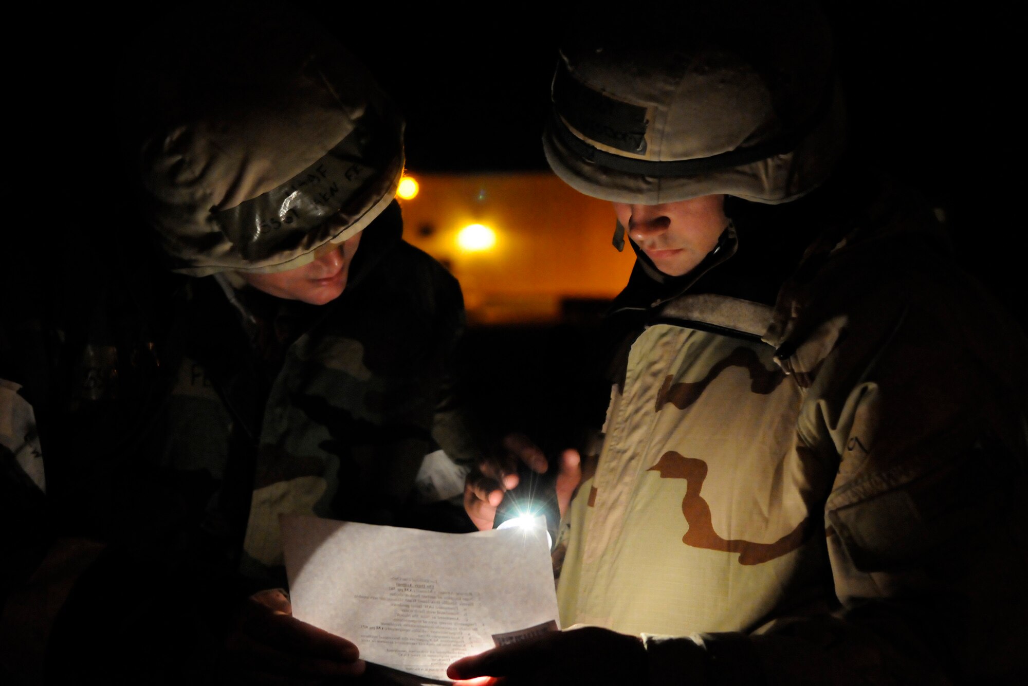 RAF MILDENHALL, England – Staff Sergeants Kenneth Fewell and Ray wisdom, 100th Logistics Readiness Squadron, double check the procedures for protecting a vehicle from chemical attack to ensure it is done right during a phase-two exercise at RAF Mildenhall, July 22.  Backup vehicles will often get covered with two layers of plastic in a very specific way so that in the event of contamination the vehicle is not rendered useless.  (U.S. Air Force photo by Staff Sgt. Christopher L. Ingersoll)
