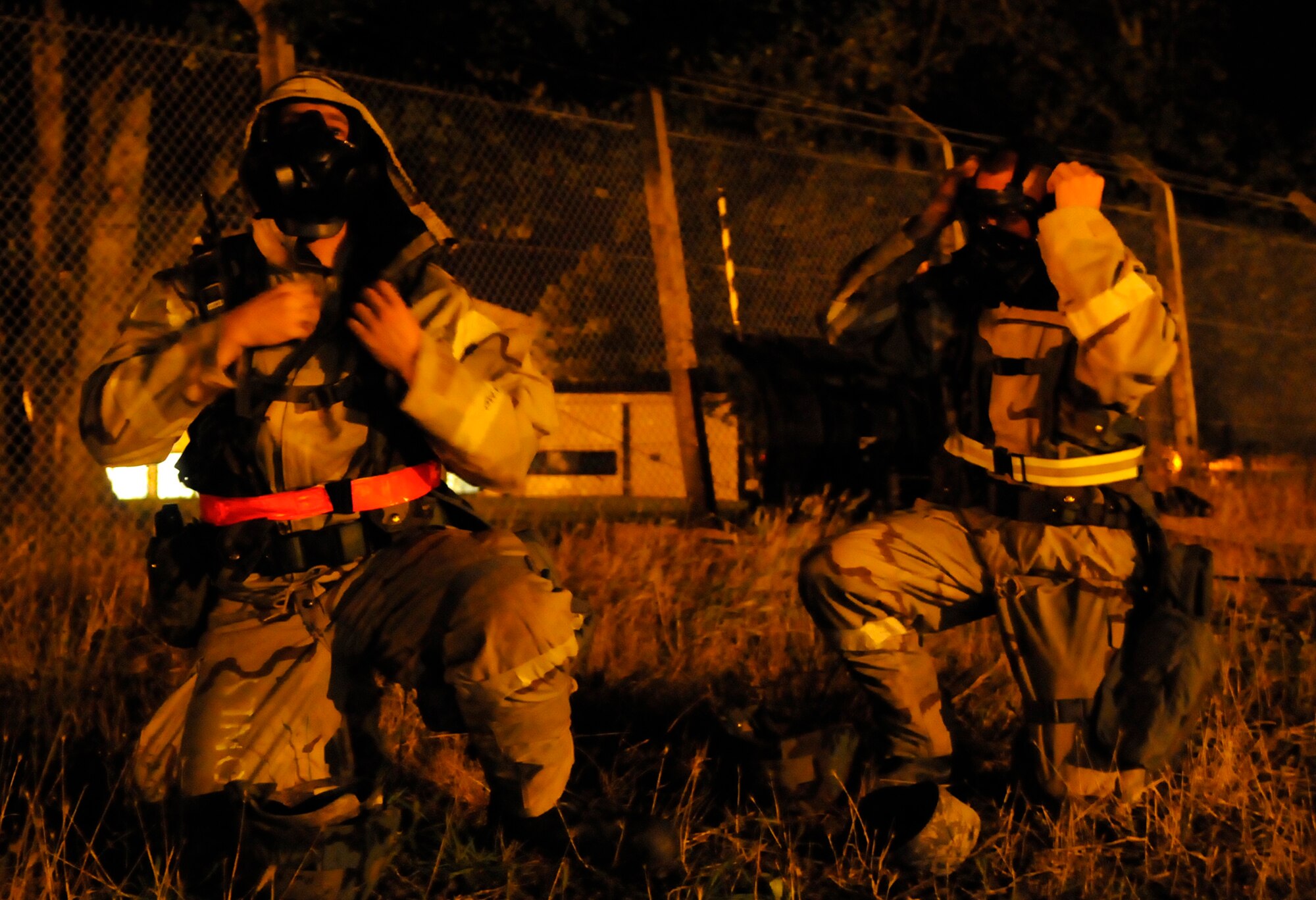RAF MILDENHALL, England – Airman 1st Class Cody Seymour and Staff Sgt. Marc Bakker, both from the 100th Civil Engineer Squadron, don gas masks during a phase-two exercise July 22.  Airman Seymour and Staff Bakker are both members of the damaged airfield reconnaissance team that sweeps the runway area after any simulated attack to check for damage or unexploded ordinance.  (U.S. Air Force photo by Staff Sergeant Christopher L. Ingersoll)
