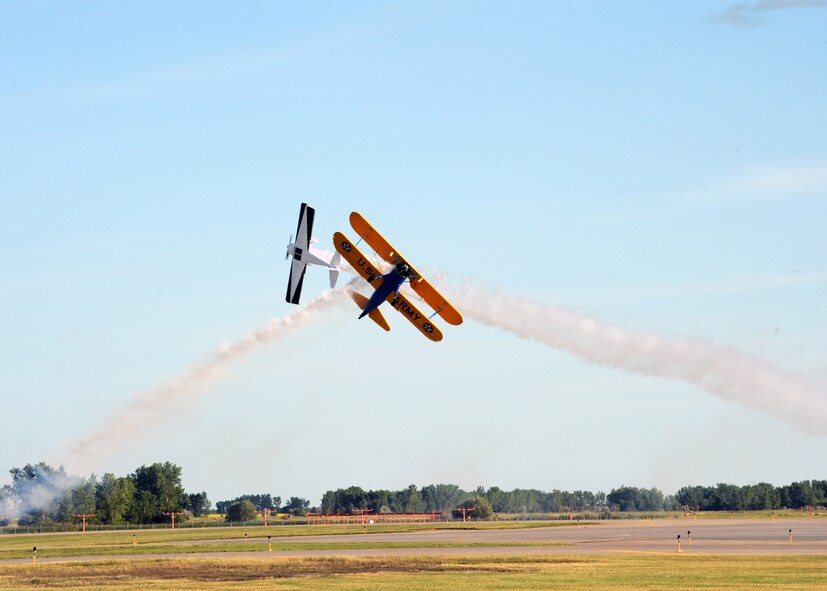 MINOT AIR FORCE BASE, N.D. -- A PT-17 Stearman, yellow and blue aircraft, piloted by John Mohr of Minot, N.D. and a 1946 Clipped-Wing Taylorcraft airplane, white and navy blue aircraft, piloted by Warren Pietsch, cross in front of the crowd at Northern Neighbor’s Day here July 18. Thousands of people from the base and local community turned out to watch the 2009 Northern Neighbors Day, which came through on its promise to wow spectators with amazing aerial maneuvers, nail-biting choreography, historic displays and much more.  (U.S. Air Force photo by Staff Sgt. Keith Ballard) 