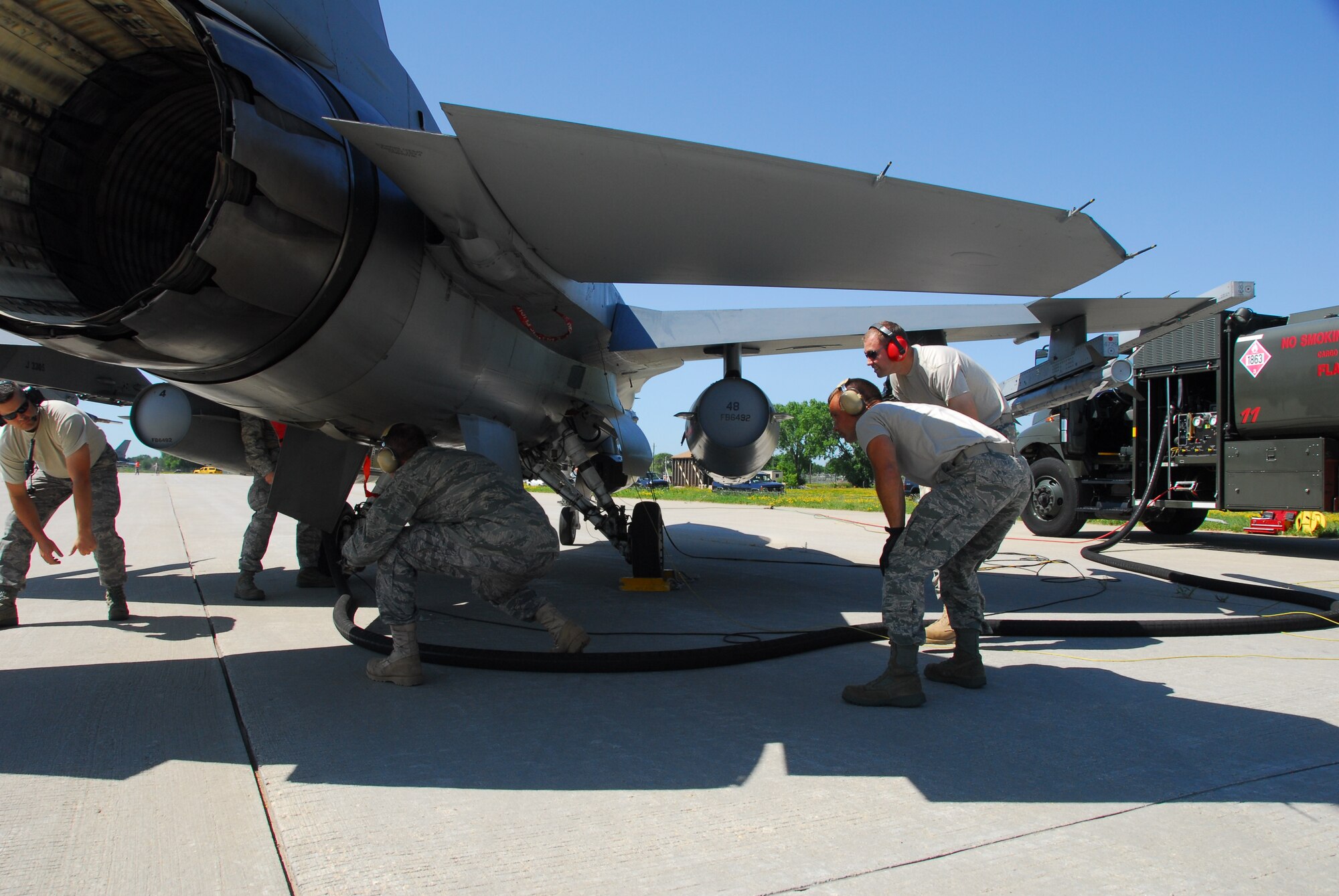 Members of the 115th Fighter Wing, Wisconsin Air National Guard, perform hot pit refueling, June 27, 2009.  Hot pit operations allow the refueling of aircraft with its engine running, allowing for fast turn times between missions.  (U.S. Air Force photo by Staff Sgt. Ashley Bell)