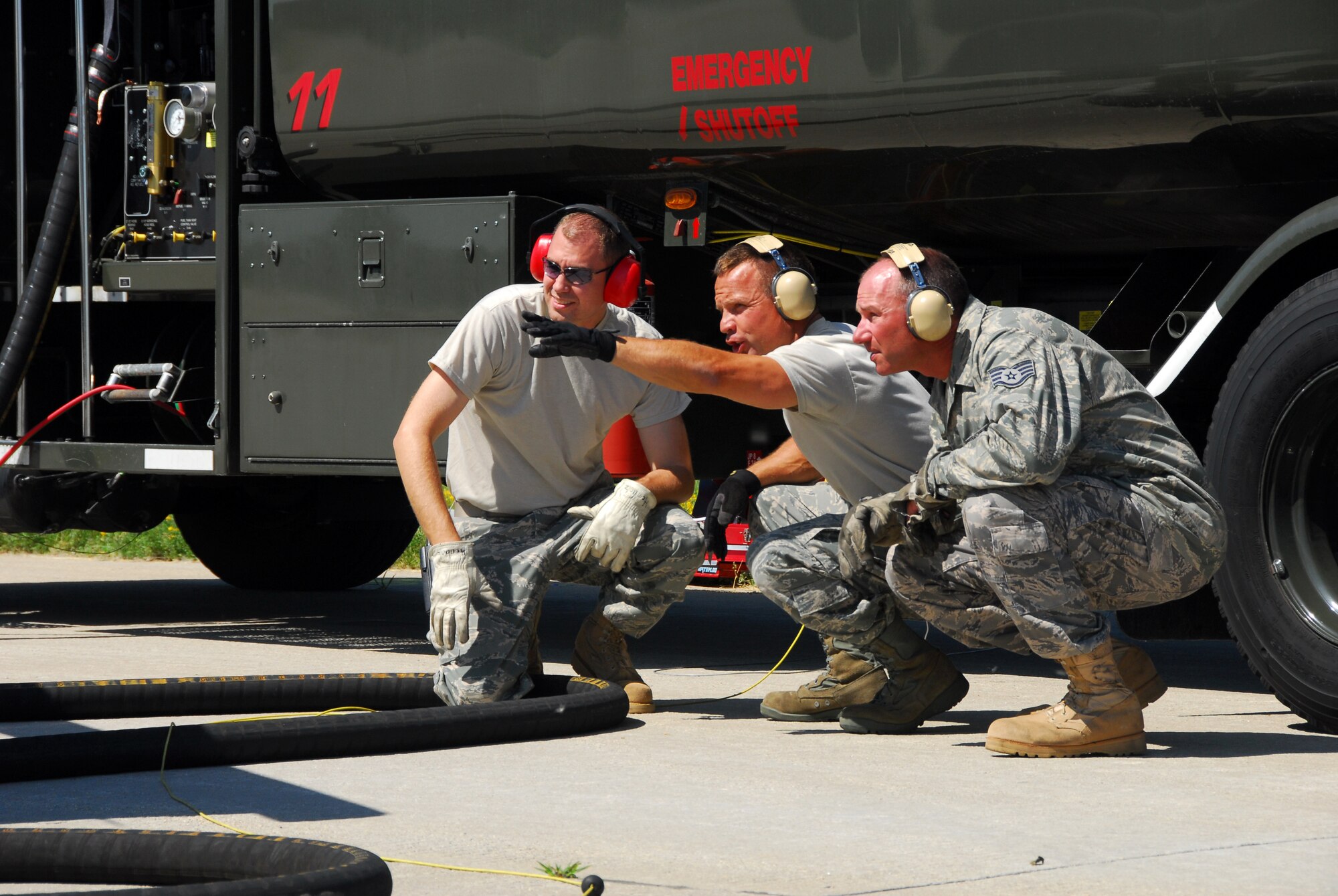 Staff Sgt. John Brown, center, a Refueling Unit Mechanic with the 115th Fighter Wing, Wisconsin Air National Guard, points out areas of danger to avoid to Staff Sgt. Shaun Herholz, left, and Staff Sgt. Patrick Brown, during hot pit operations on one of the unit's F-16Cs, June 27, 2009.  Hot pit operations allow the refueling of aircraft with its engine running, allowing for fast turn times between missions. (U.S. Air Force photo by Staff Sgt. Ashley Bell)