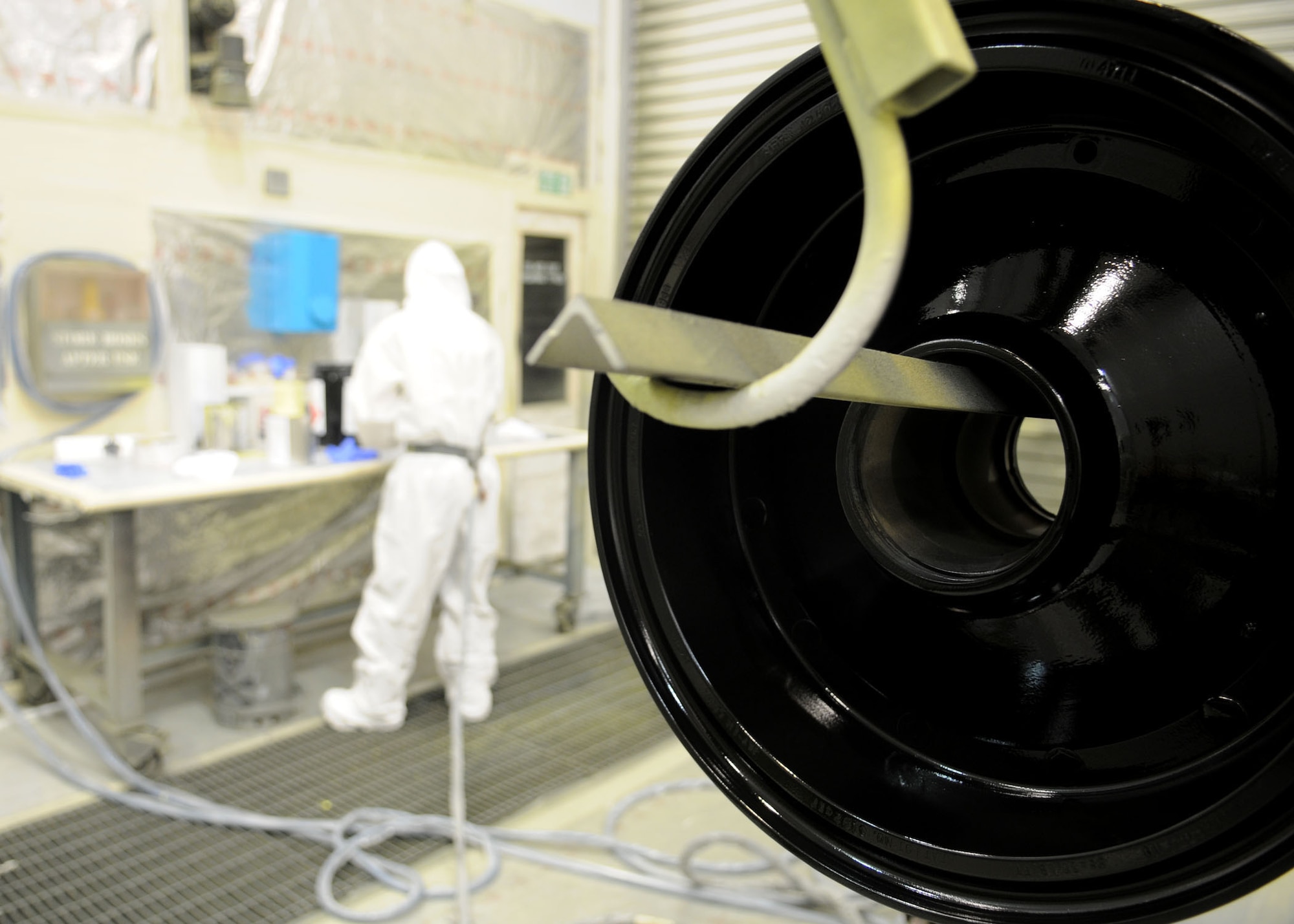 RAF MILDENHALL, England--A freshly painted aircraft wheel sets while Airman 1st Class Robert Greenwell, 100th Maintenance Squadron, aircraft structural maintenance technician, cleans up his work station in the background June 16, 2009. Airman Greenwell paints a wide variety of aircraft parts and support equipment daily. (U.S. Air Force photo by Staff Sgt. Jerry Fleshman)