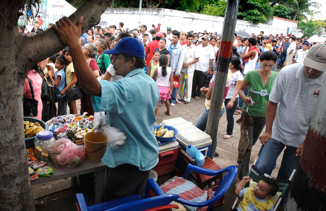 Hundreds wait in line for medical care in Chinandega, Nicaragua, July 11, 2009. The U.S. Navy hospital ship USNS Comfort was offshore to provide medical care as part of Continuing Promise 2009, during a four-month, seven-country humanitarian mission. The scene was carnival-like with a local disc jockey playing music and vendors selling water, soda and slices of watermelon. Patients not seen the first day slept in the street that night to be first in line the next day.