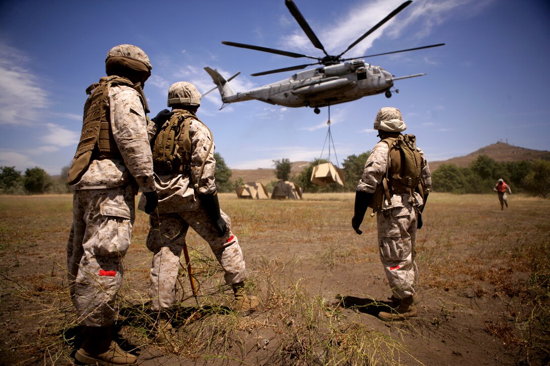 U.S. Marines watch as the 12,000 pound target they attached is lifted by a CH-53E from Marine Heavy Helicopter Squadron 465 on Marine Corps Air Station Miramar, Calif., July 14, 2009. The targets will be used for live fire training on Camp Pendleton, Calif. The Marines are assigned to the 1st Marine Logistics Group's Landing Support Company, Combat Logistics Regiment 17.