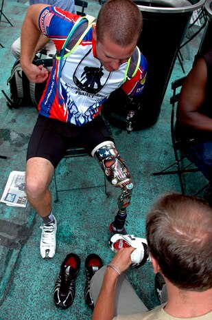 An injured soldier receives help to change his shoes for the Wounded Warrior Project Soldier Ride, New York City, July 23. The bicycle ride through Manhattan is part of the organization’s goal to raise awareness for those who have been injured while fighting overseas. (Marine Corps photo by Sgt. Randall A. Clinton)