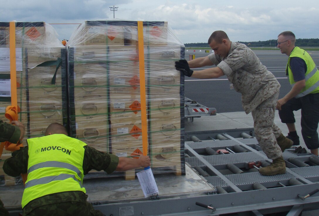 Sgt. Carson Boekhoven (near right), Marine Forces Europe strategic mobility non-commissioned officer, helps a group of Estonian soldiers load a pallet of ammunition onto a U.S. Air Force C-17 aircraft. Boekhoven and the Marine Forces Europe Strategic Mobility Office supported the Estonian military during a recent deployment of an Estonian infantry company to Afghanistan.