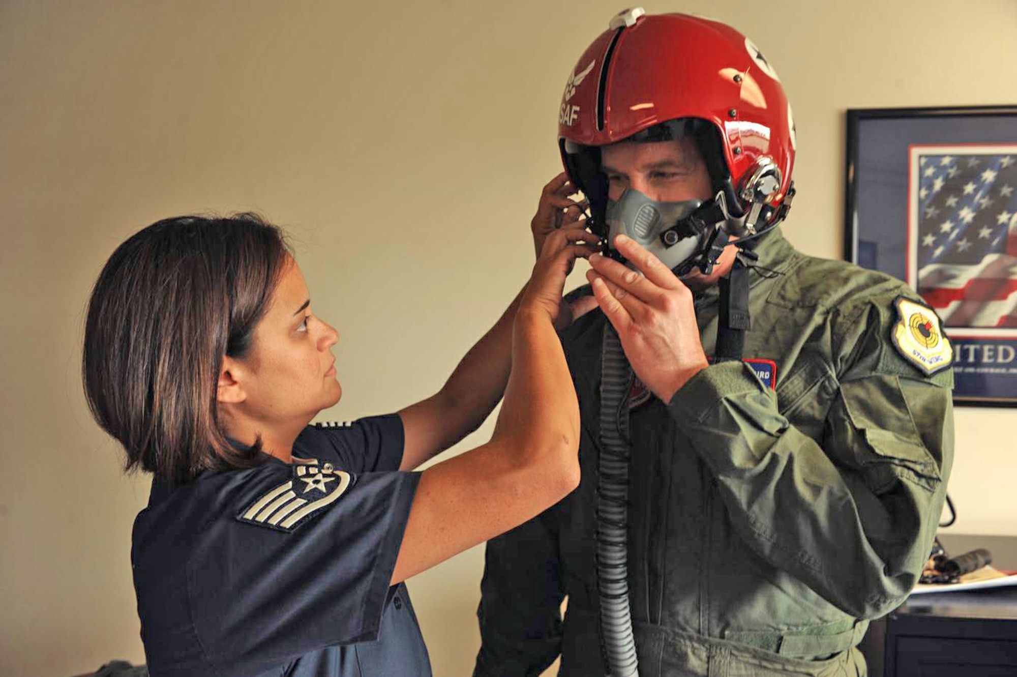 Staff Sgt. Robbin Bailon, aircrew flight equipment specialist, fits a helmet to Jeff Skiles prior to his flight with the Thunderbirds July 23. Mr. Skiles was the co-pilot for U.S. Airways Flight 1549 that crashed into the Hudson River in New York in January. (U.S. Air Force photo/Staff Sgt. Kristi Machado)