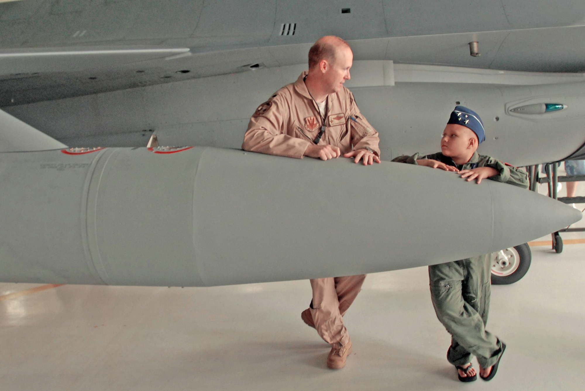 Lt. Col. Chris Hardgrave talks with Kayla Kiley alongside an F-16 Fighting Falcon during the Pilot for a Day Program July 23 at Andrews Air Force Base, Md. Colonel Hardgrave is an F-16 pilot with the 121st Fighter Squadron. (U.S. Army photo/Sgt. 1st Class Jon 
Soucy)
