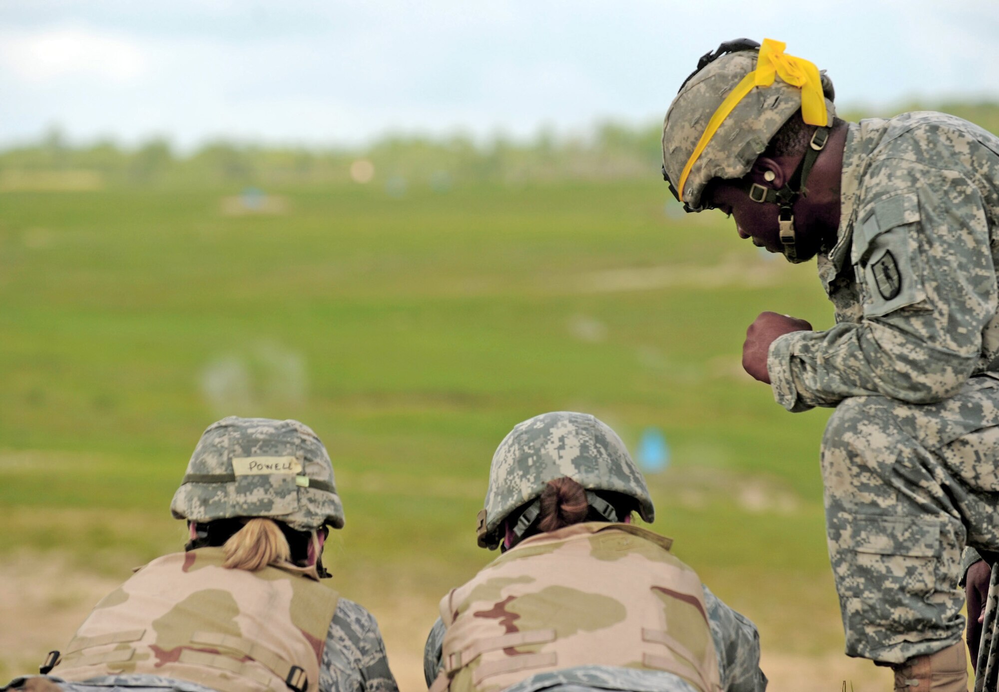 Army Staff Sgt. Edward Stokes instructs two Airmen on how to shoot the M249 machine gun during combat weather training July 16 at Camp Blanding, Fla. The Airmen are participating in a 30-day course with Air Force and Army instructors. Sergeant Stokes is assigned to the 211th Regiment, Regional Training Institute. (U.S. Air Force photo/Senior Airman Gina Chiaverotti-Paige)