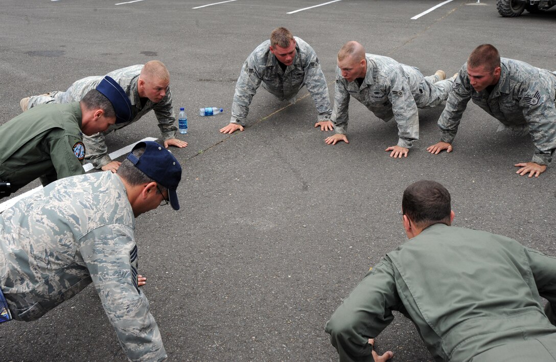 Col. Jamie Crowhurst, 22nd Air Refueling Wing commander, and Chief  Timothy Horn, 22nd ARW Command Chief, do 22 push-ups with Airmen who just finished representing Team McConnell in a combat endurance competition for security forces at RODEO 2009. One of the Airmen (at center) is Senior Airman Nathaniel Shelley, a Reservist assigned to the 931st Air Refueling Group. (U.S. Air Force photo/Tech. Sgt. Chyrece Campbell)  