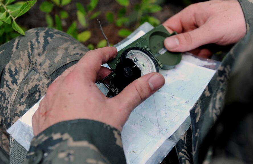 MOODY AIR FORCE BASE, Ga. -- A candidate from the air liaison officer selection course checks his directions using a compass and a map during a land navigation assignment here July 21. This assignment challenges candidate to navigate through woodland terrain and locate their destination using only essential items of survival. (U.S. Air Force photo by Airman 1st Class Joshua Green)