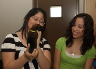 7/18/2009 - Reveca Cahue (left) holds a military working puppy during her visit to Lackland's puppy whelping center July 18. Ms. Cahue and her family, including her sister Connie (right), also saw a military working dog demonstration during their tour. (U.S. Air Force photo/Alan Boedeker) 