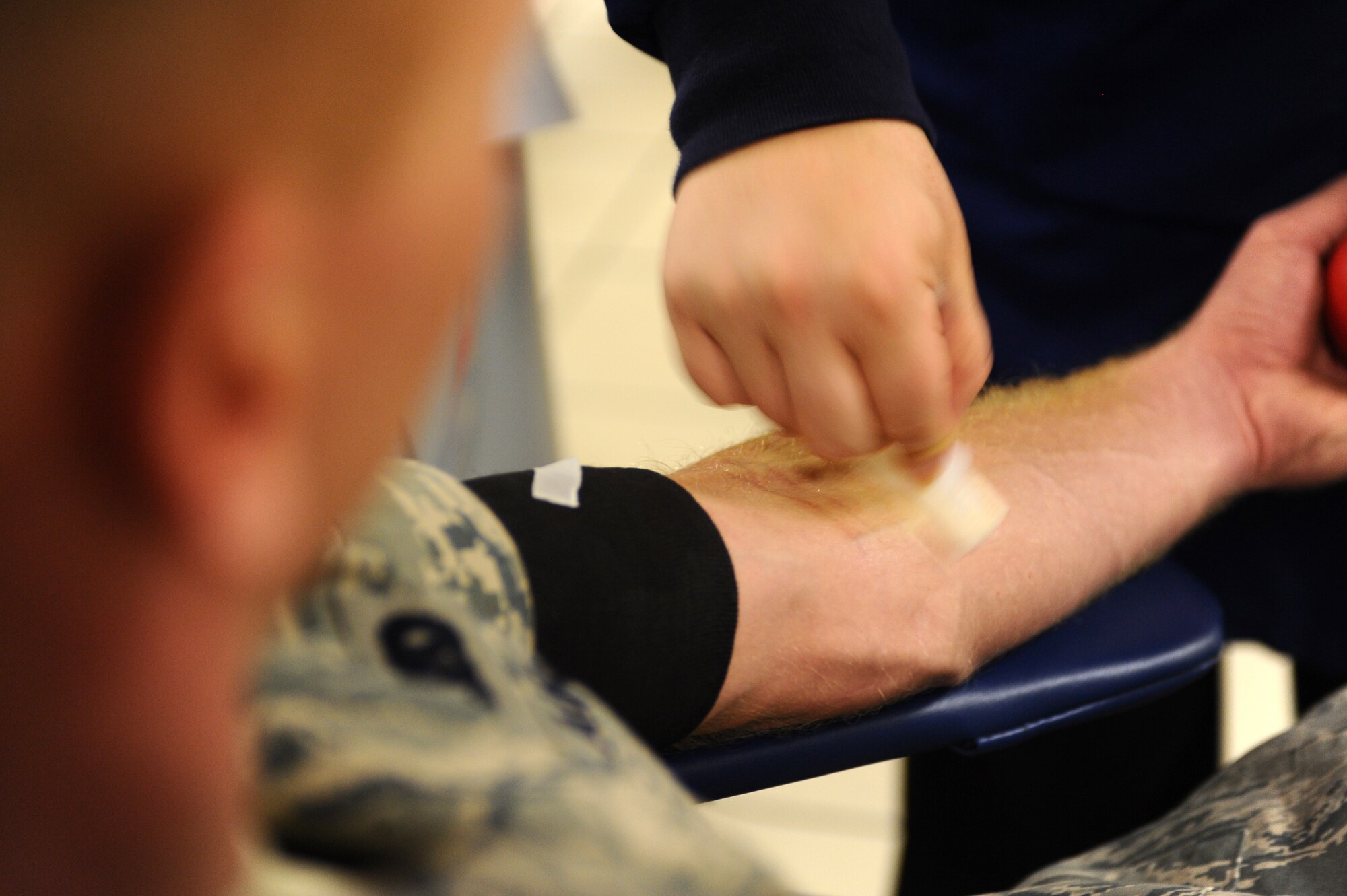 Airman 1st Class Steven Sliger, 28th Logistics Readiness Squadron fire truck maintenance apprentice, watches Erin Hudack, United Blood Services assistant donor care supervisor, clean his arm before he gives a blood donation here, July 23. Airman Sliger’s donation contributed to the 186 units of blood Ellsworth members donated to the United Blood Services. (U.S. Air Force photo/Senior Airman Kasey Zickmund)