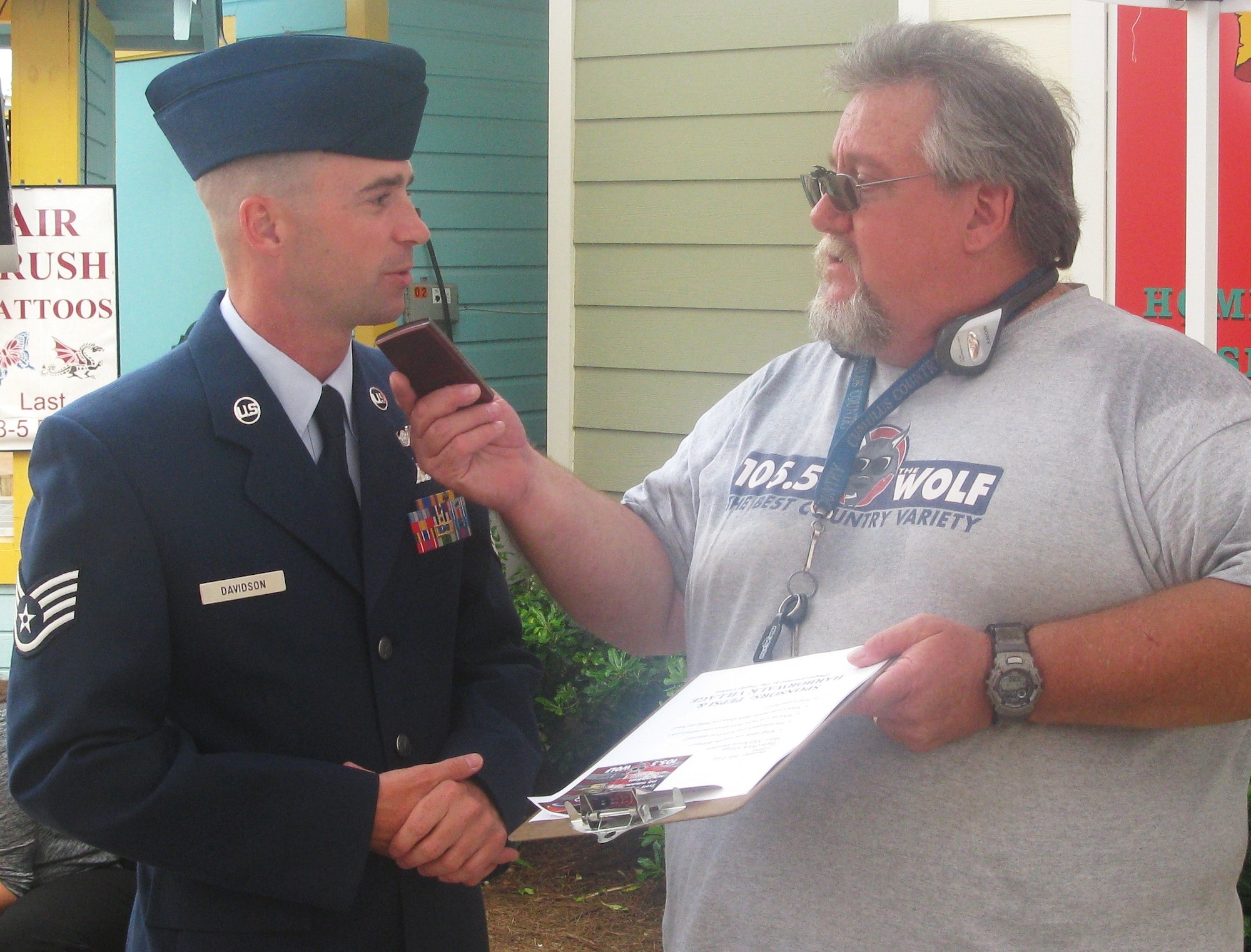 Staff Sgt. Kevin Davidson, 40th Flight Test Squadron aerial photographer, is interviewed by 105.5 "The Wolf" DJ Skip Davis during Destin's Red, White and Blue celebration July 23, at Harbor Walk Village.  Sergeant Davidson was honored as the military hero during the event.  (U.S. Air Force photo/Leslie Brown)