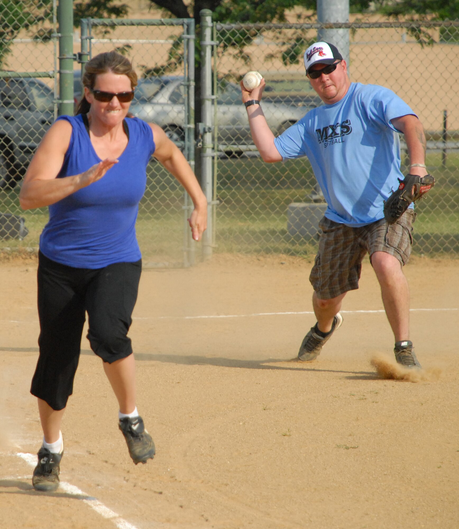Kristin Bailey, 436th Force Support Squadron center right fielder, tries to beat the throw to first base during an intramural softball game against the 436th Maintenance Squadron.  436th MXS defeated 436th FSS 16 ? 1.  (U.S. Air Force photo/Matthew Hubby)