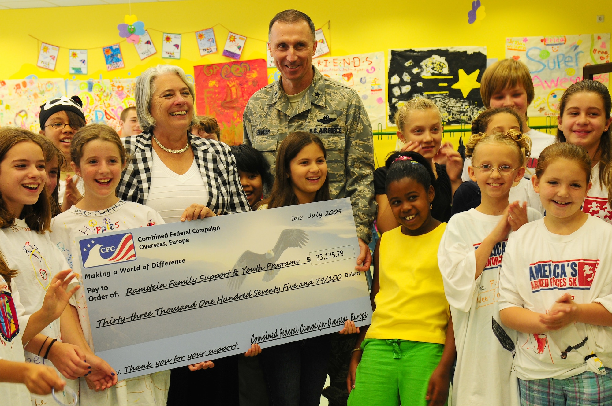 Renee Acosta, president and CEO of Global Impact, Department of Defense campaigns management organization for the Combined Federal Campaign-Overseas presents a ceremonial check for more than $30,000 Jul. 21 to presents Brig. Gen. Bill Bender, 86th Airlift Wing and Kaiserslautern Military Community commander at the youth center, Ramstein Air Base, Germany. The check represents donations that civilian and military employees in Ramstein donated to Family Support and Youth Programs through CFC-O during the 2008 campaign. (U.S. Air Force photo by Airman 1st Class Alexandria Mosness)