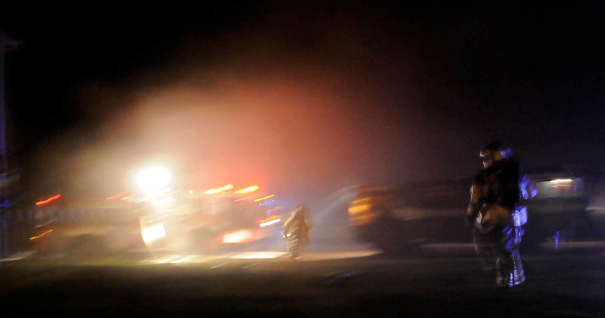 RAF MILDENHALL, England – Firefighters rush back to their truck to supply water to their hoses as part of a building-fire scenario played out during a phase-two exercise July 23.  The phase two helps Airmen practice and streamline mission essential war tasks that could be performed downrange.  (U.S. Air Force photo by Staff Sgt. Christopher L. Ingersoll)