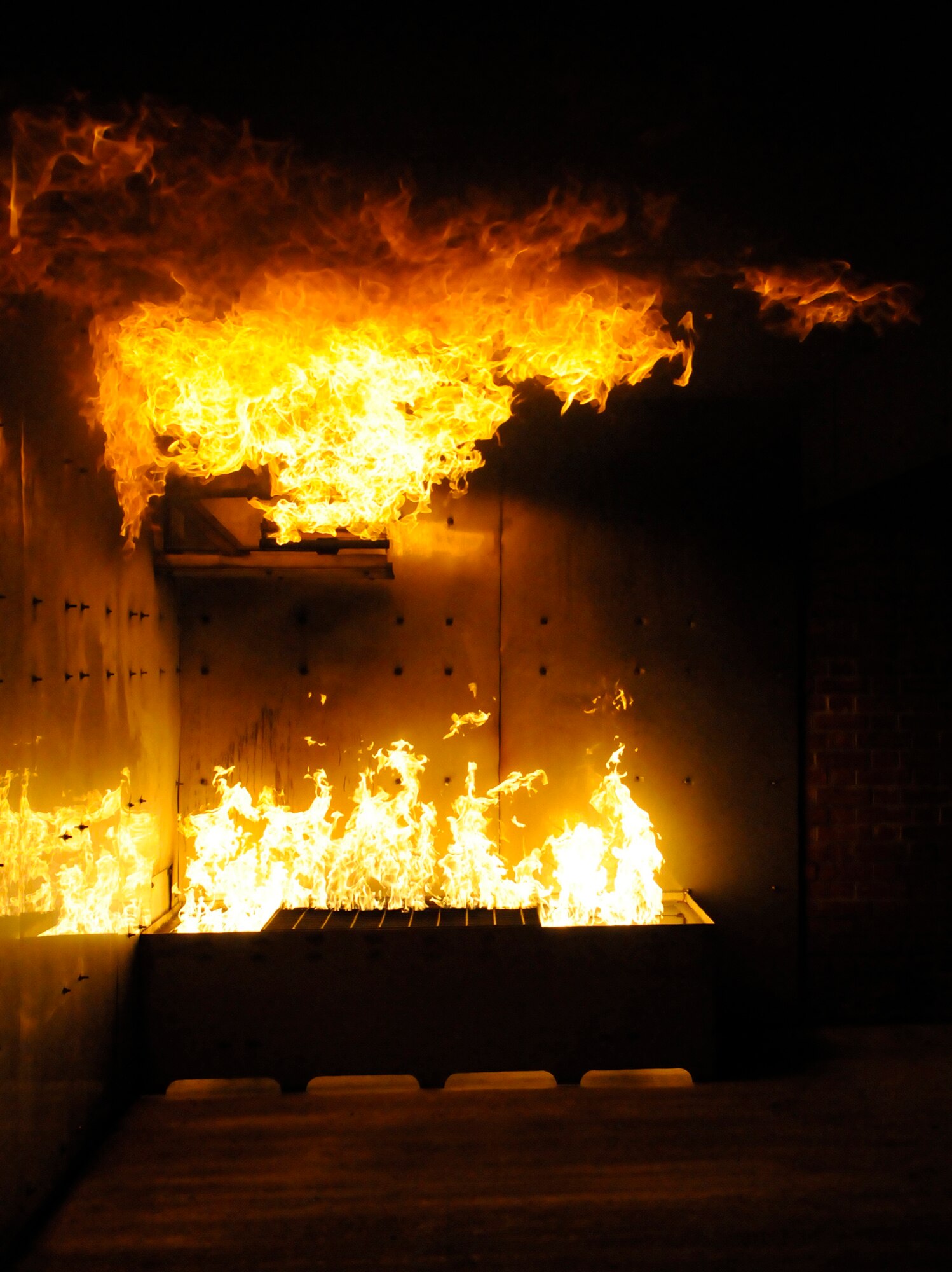 RAF MILDENHALL, England – Raging hot fire awaits the RAF Mildenhall firefighters at the "burn pit" as one of the phase-two exercise scenarios July 23.  The firefighters will need to put out the fire and remove simulated victims from the building as within specific time limits and criteria.  (U.S. Air Force photo by Staff Sgt. Christopher L. Ingersoll)