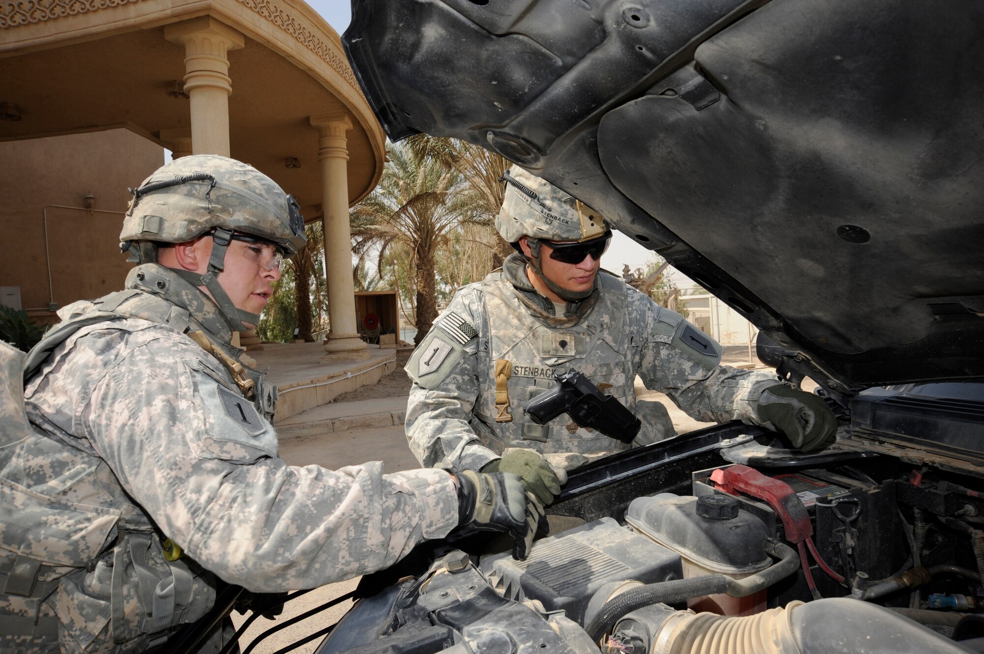BAGHDAD, Iraq - Prior to the start of a mission, Army Staff Sgt. Justin Conway (left) and Spc. Andrew Stenback (right) perform preventative maintenance checks on their vehicle to ensure it will function properly during missions here July 20, 2009. The personal security detail team provides constant security to ensure the individual they are assigned to is transported safely and securely to, from and inside various locations. Sergeant Conway is originally from Denver, Colo., and Specialist Stenback is from Miami, Fla. Both are deployed from the 2nd Brigade Heavy Combat Team, 1st Infantry Division, Fort Riley, Kan. (U.S. Air Force photo/Tech. Sgt. Johnny L. Saldivar/Released)
