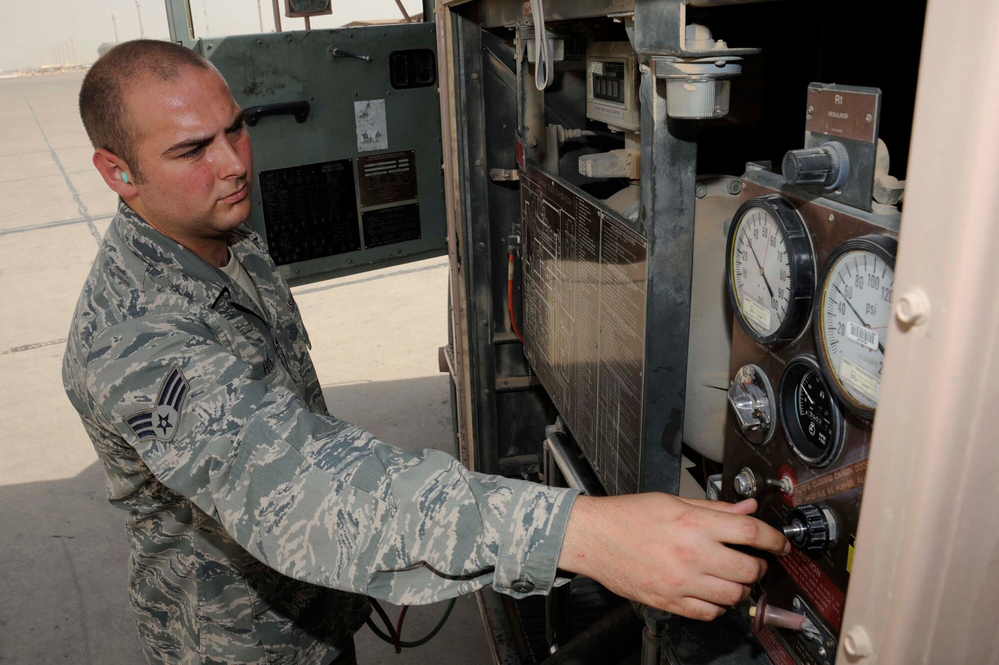 SATHER AIR BASE, Iraq -- Senior Airman Eric Hyde, 447th Expeditionary Logistics Readiness Squadron refueling mechanic, controls the flow of fuel from his R11 fuel truck to an aircraft on the flight line here July 20, 2009. Fuel can be pumped at 600 gallons a minute from a fuel truck into an aircraft. Airman Hyde is deployed from McConnell Air Force Base, Kan., and is originally from Macon, Mo. (U.S. Air Force photo/Tech. Sgt. Johnny L. Saldivar/Released)