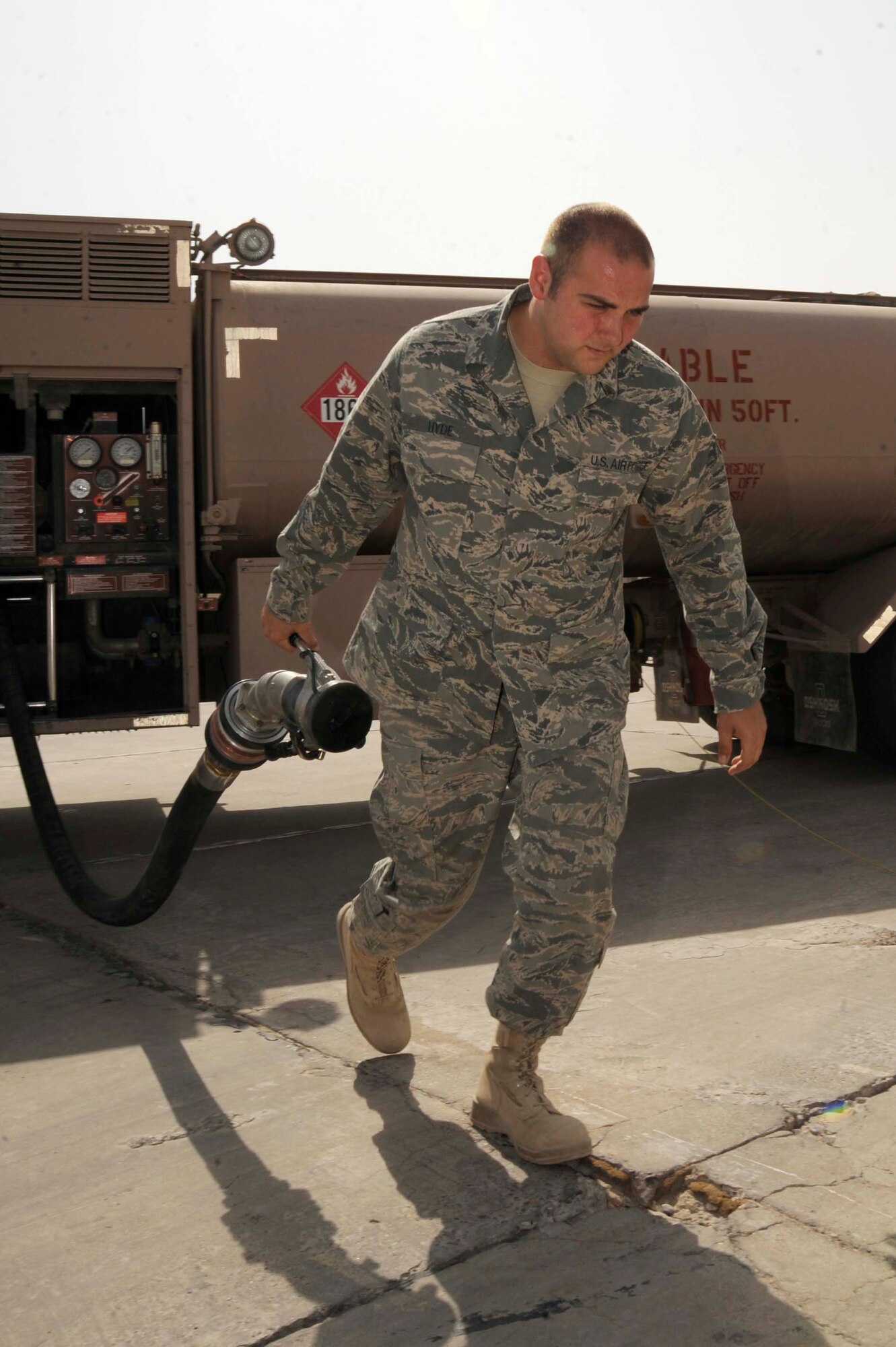 SATHER AIR BASE, Iraq -- Senior Airman Eric Hyde, 447th Expeditionary Logistics Readiness Squadron refueling mechanic, pulls a fuel hose from his R11 fuel truck to refuel an aircraft on the flight line here July 20, 2009. Fuel can be pumped at 600 gallons a minute from a fuel truck into an aircraft. Airman Hyde is deployed from McConnell Air Force Base, Kan., and is originally from Macon, Mo. (U.S. Air Force photo/Tech. Sgt. Johnny L. Saldivar/Released)