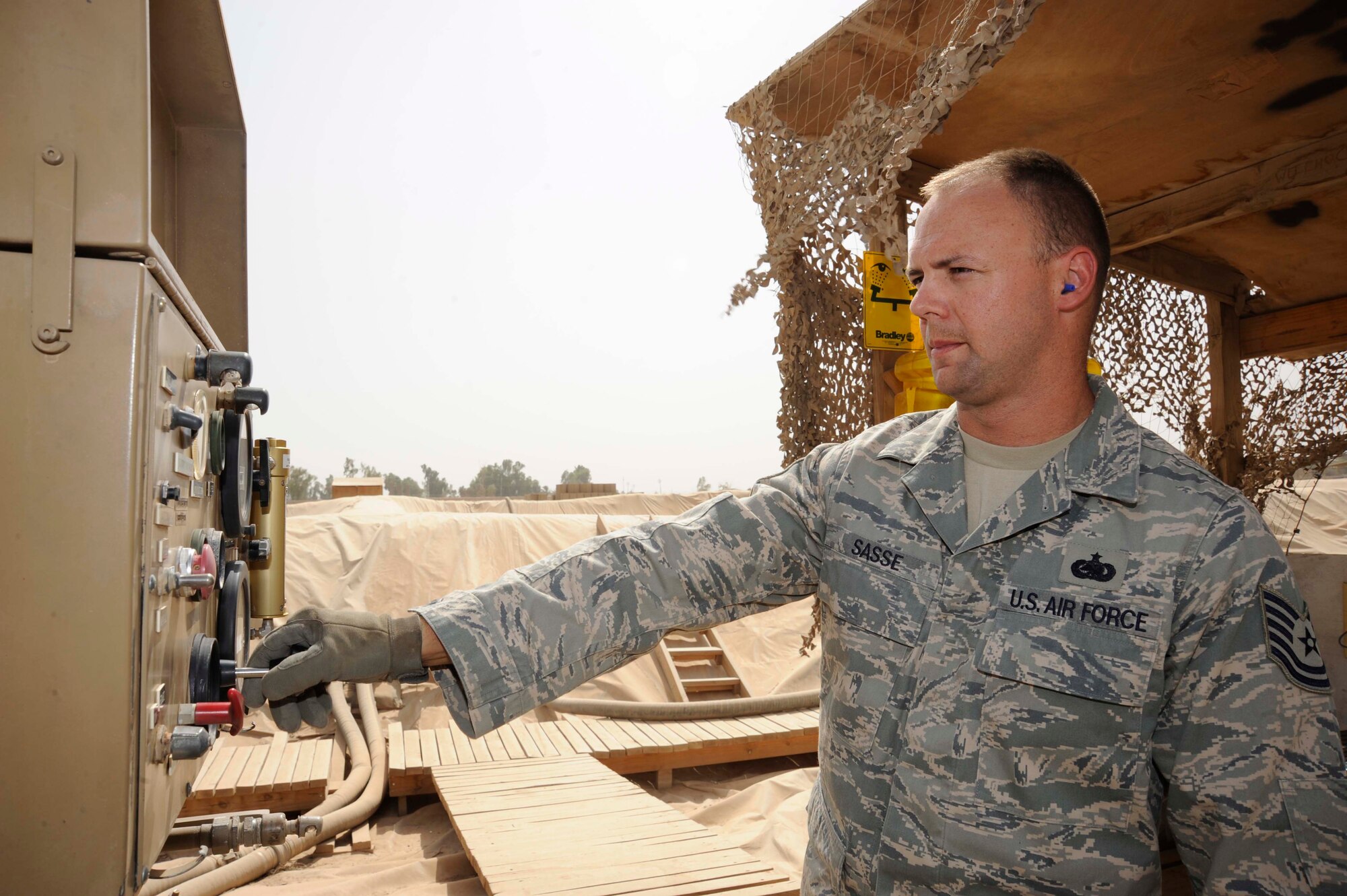 SATHER AIR BASE, Iraq -- Tech. Sgt. Rocky Sasse, 447th Expeditionary Logistics Readiness Squadron noncommissioned officer in charge of fuel operations, controls the flow of fuel from an R14 unit to an R11 fuel truck here July 20, 2009. The R14 allows Sergeant Sasse to pump more than 600 gallons a minute from this unit into fuel trucks used to refuel Air Force, Army, United Nations and Iraqi air force aircraft. Sergeant Sasse is deployed from McConnell Air Force Base, Kan.., and is originally from Santa Rosa, Fla. (U.S. Air Force photo/Tech. Sgt. Johnny L. Saldivar/Released)