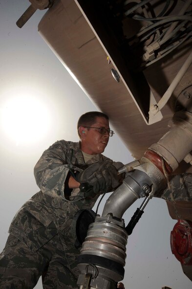SATHER AIR BASE, Iraq -- Staff Sgt. Jason Klingbiel, 447th Expeditionary Logistics Readiness Squadron fuels distribution operator, connects a fuel hose from an R14 fuel unit to the bottom loader of his R11 fuel truck here July 20, 2009. The Madison, Wis., native is on a personal mission to break a record by pumping more than one million gallons of fuel during his deployment. Sergeant Klingbiel is deployed from the 115th Fighter Wing, Wisconsin Air National Guard. (U.S. Air Force photo/Tech. Sgt. Johnny L. Saldivar/Released)