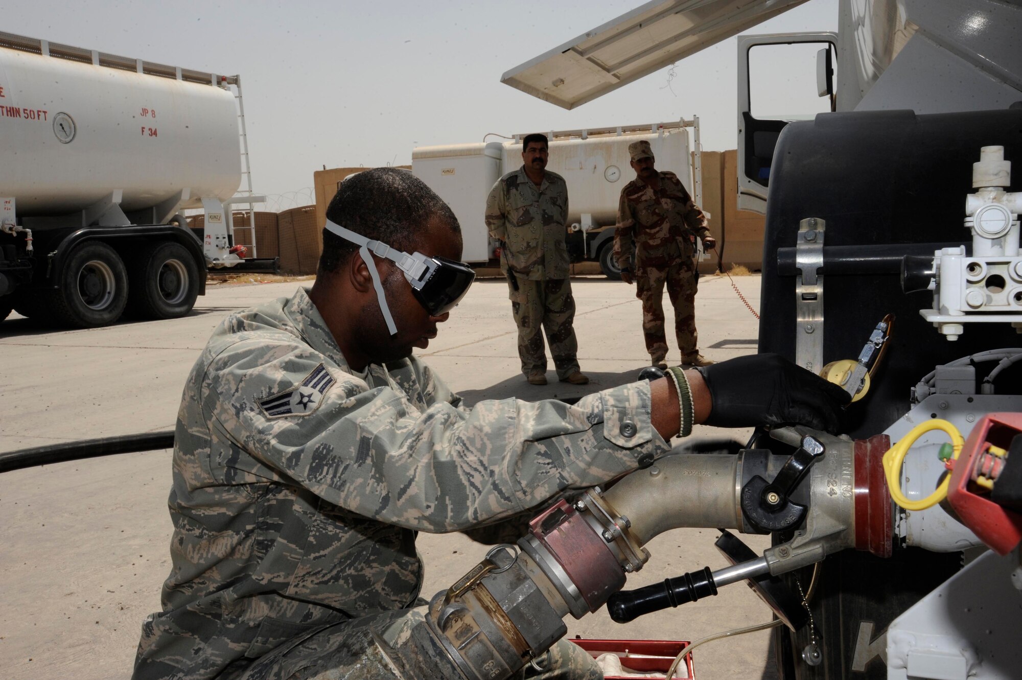 SATHER AIR BASE, Iraq -- Senior Airman David Britt, 447th Expeditionary Logistics Readiness Squadron fuels lab technician, retrieves a fuel sample from "Frankenstein." The "Frankenstein," which was built primarily by Airman Britt, is a connection designed to re-circulate fuel through the hose to the apparatus allowing an individual to safely retrieve a fuel sample. Samples are taken weekly and used to test the fuel for water and sediment to ensure the Iraqi air force receives the highest quality fuel possible. Airman Britt is deployed from McConnell Air Force Base, Kan., and is a native of Enterprise, Ala.  (U.S. Air Force photo/Tech. Sgt. Johnny L. Saldivar/Released)