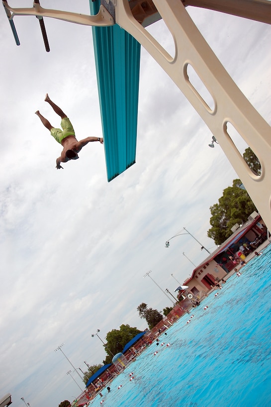 Lance Cpl. Dane Howard backflips off the high dive at the John F. Kennedy Pool in Yuma, Ariz., during the Headquarters and Headquarters Squadron family day dive contest July 24, 2009. Approximately 420 squadron service members and family members attended the social gathering, which was sponsored by Marine Corps Community Services. Chief Warrant Officer 2 David Mangum and Lance Cpl. James Brands both received a golf club for winning the biggest splash and best dive contests during the event.